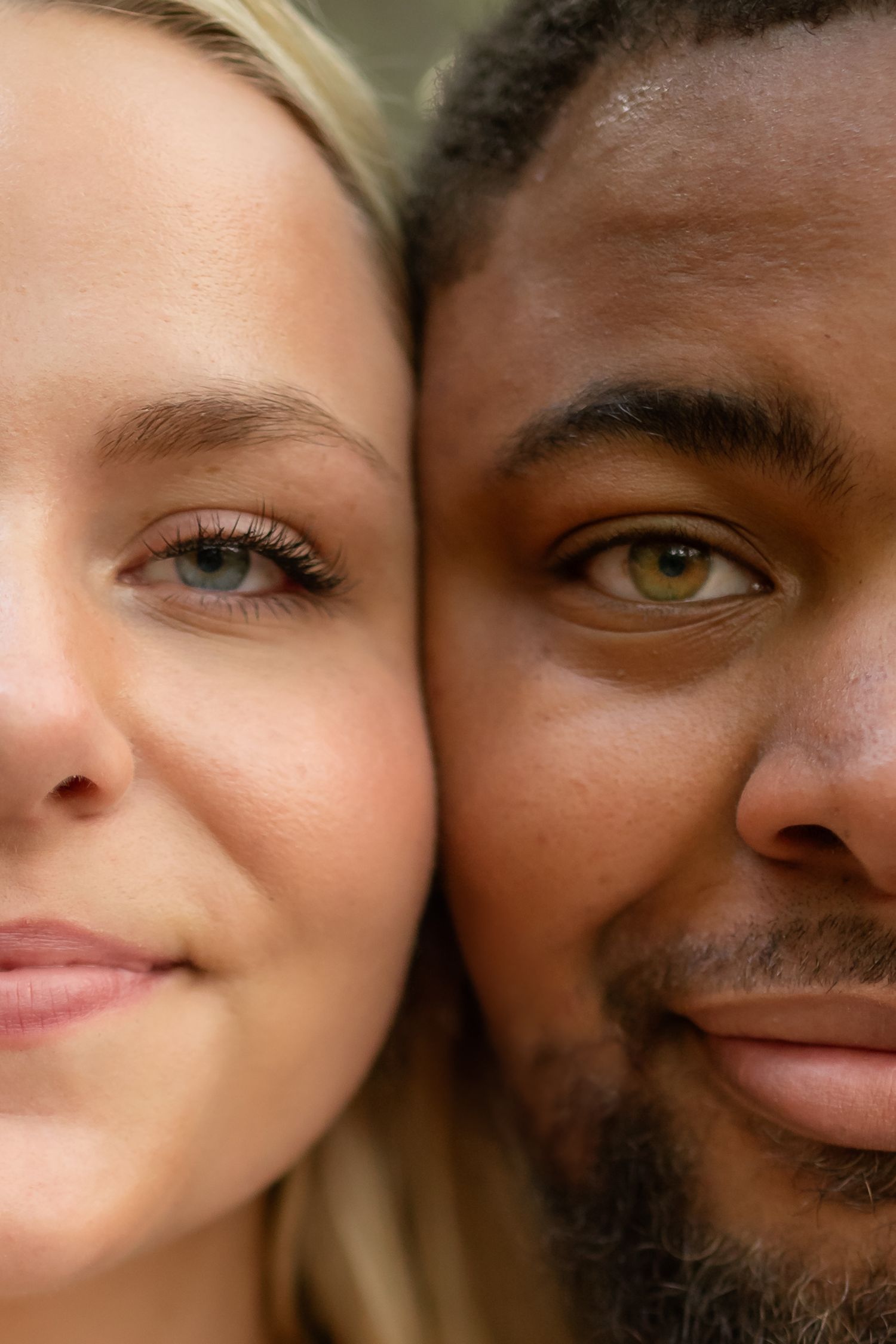 Close-up portrait of two people side by side, showing diverse skin tones and striking hazel eyes.