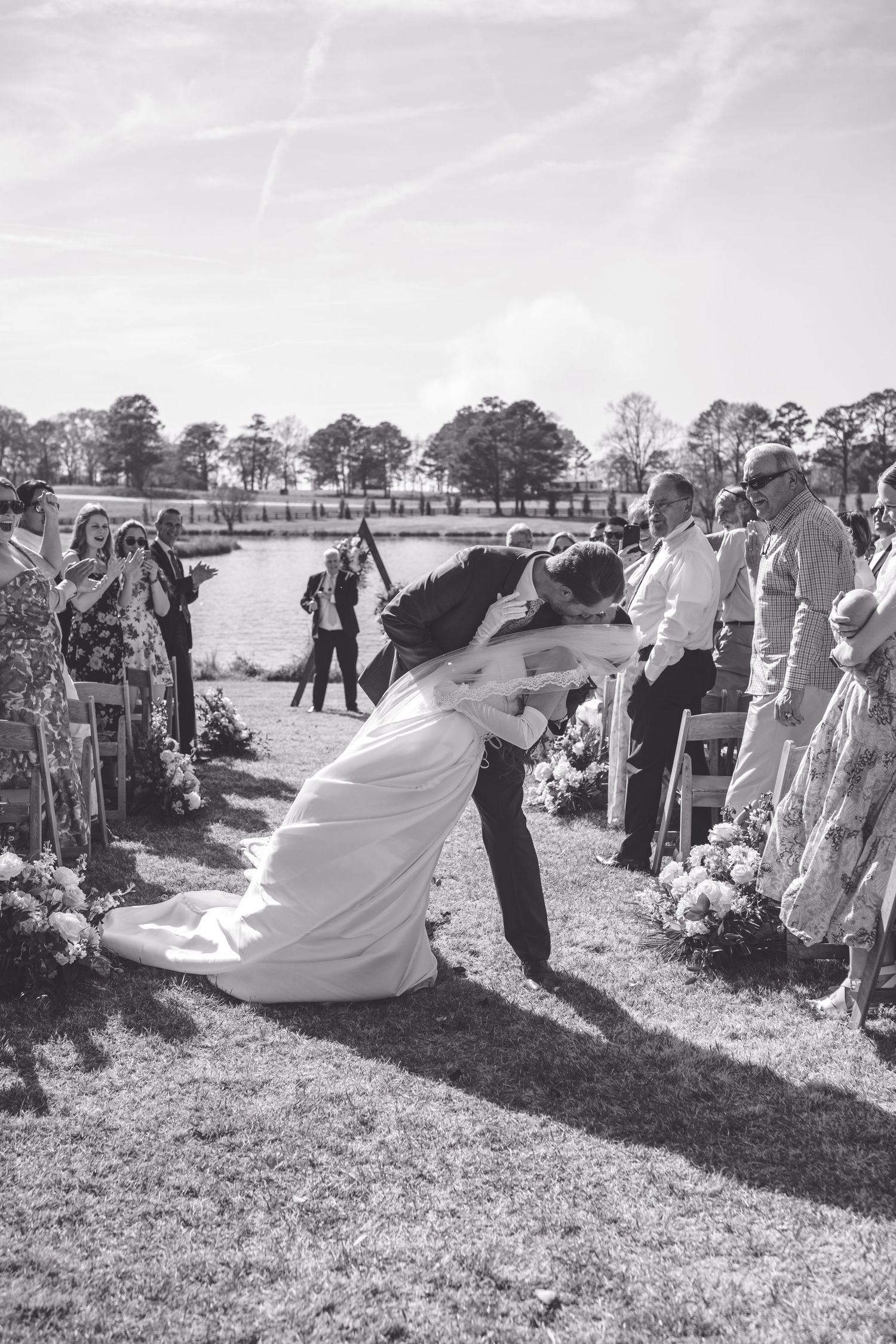 Black and white photo sequence showing wedding party guests lined up outdoors for a fun group photo activity.