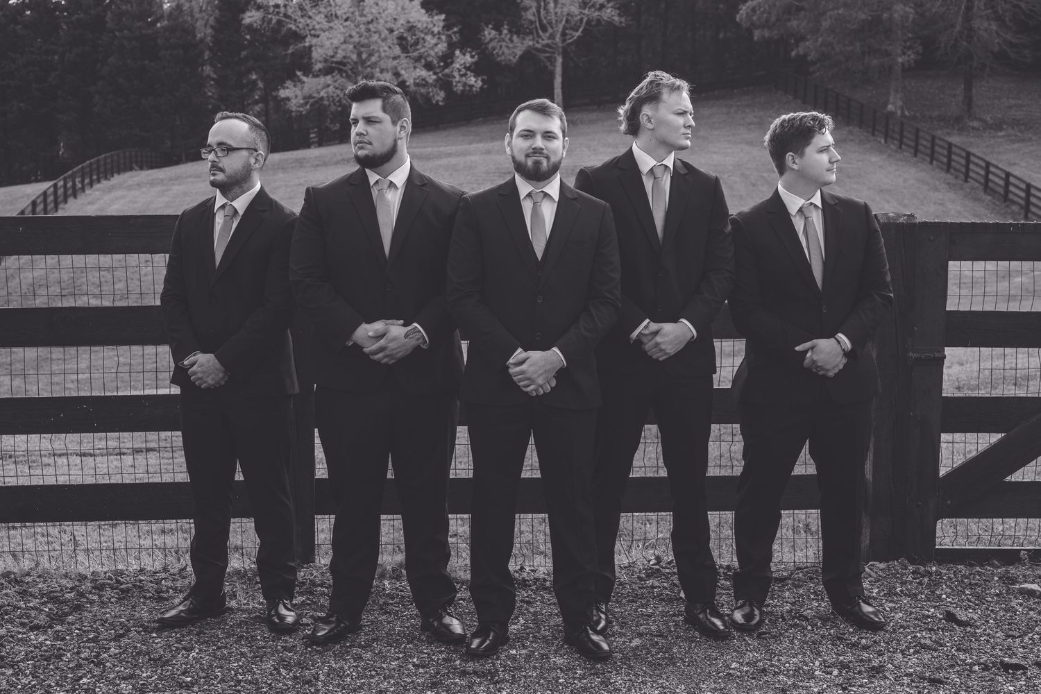 A black and white photo collage showing groomsmen in suits posing casually against a wooden fence. Southern Pines, NC