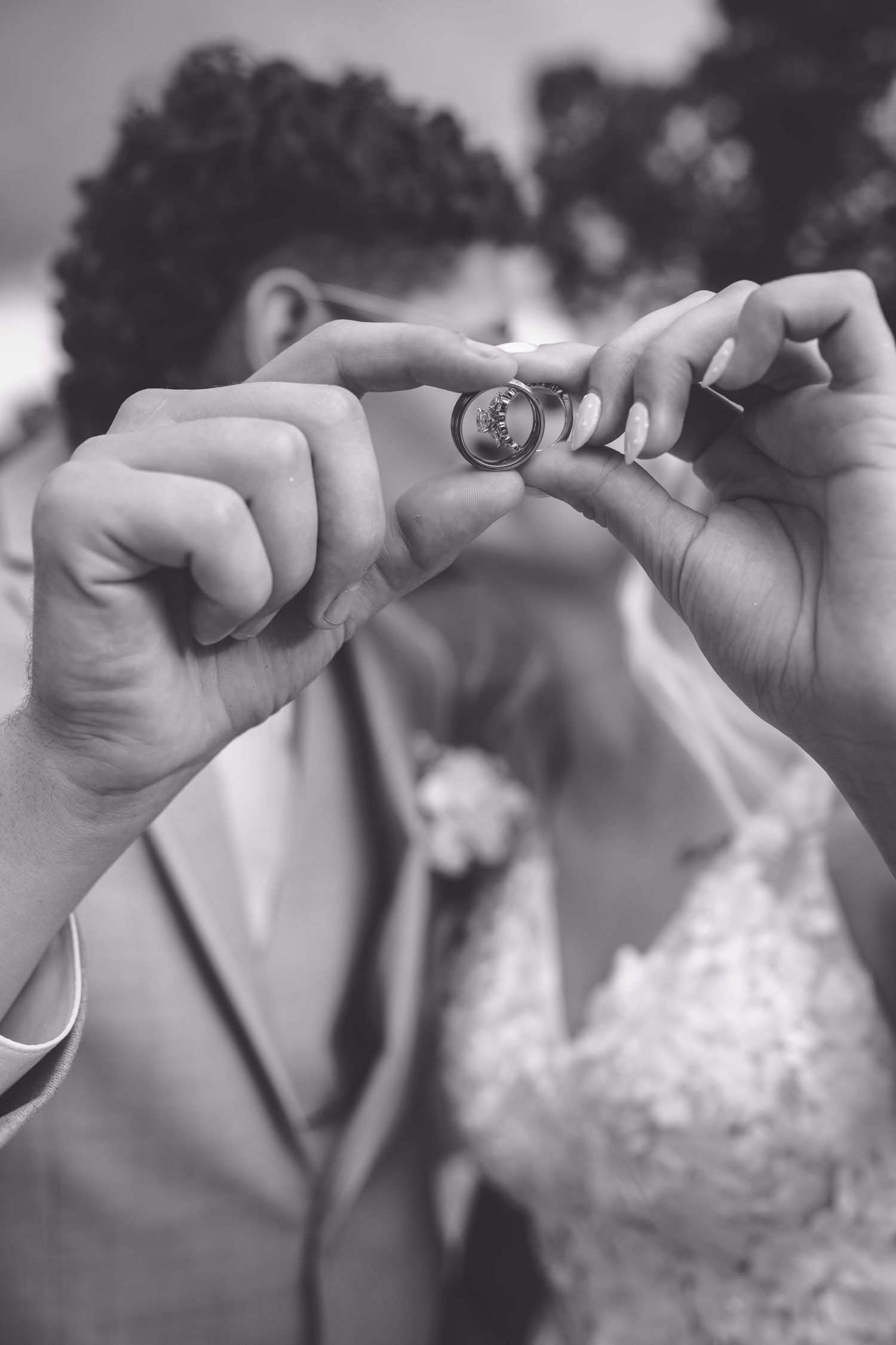 Bride and groom holding up wedding rings together at their ceremony.