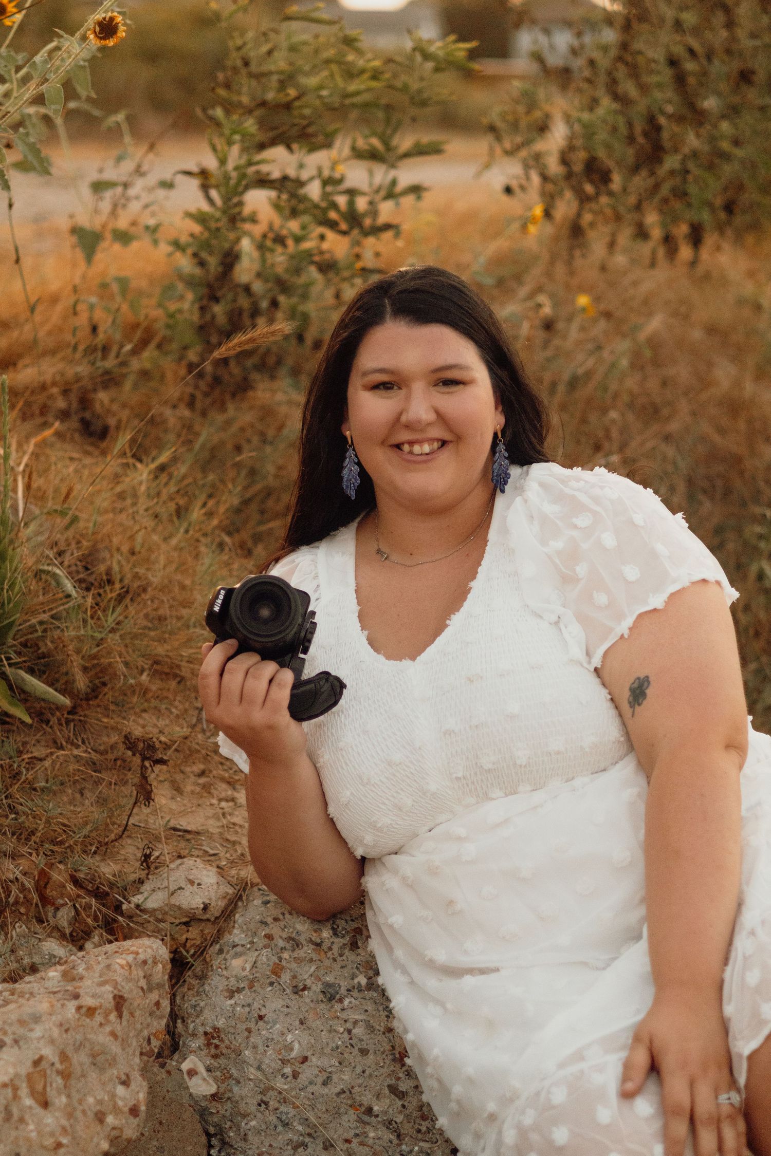 A photographer holds her camera up during a branding session for her business