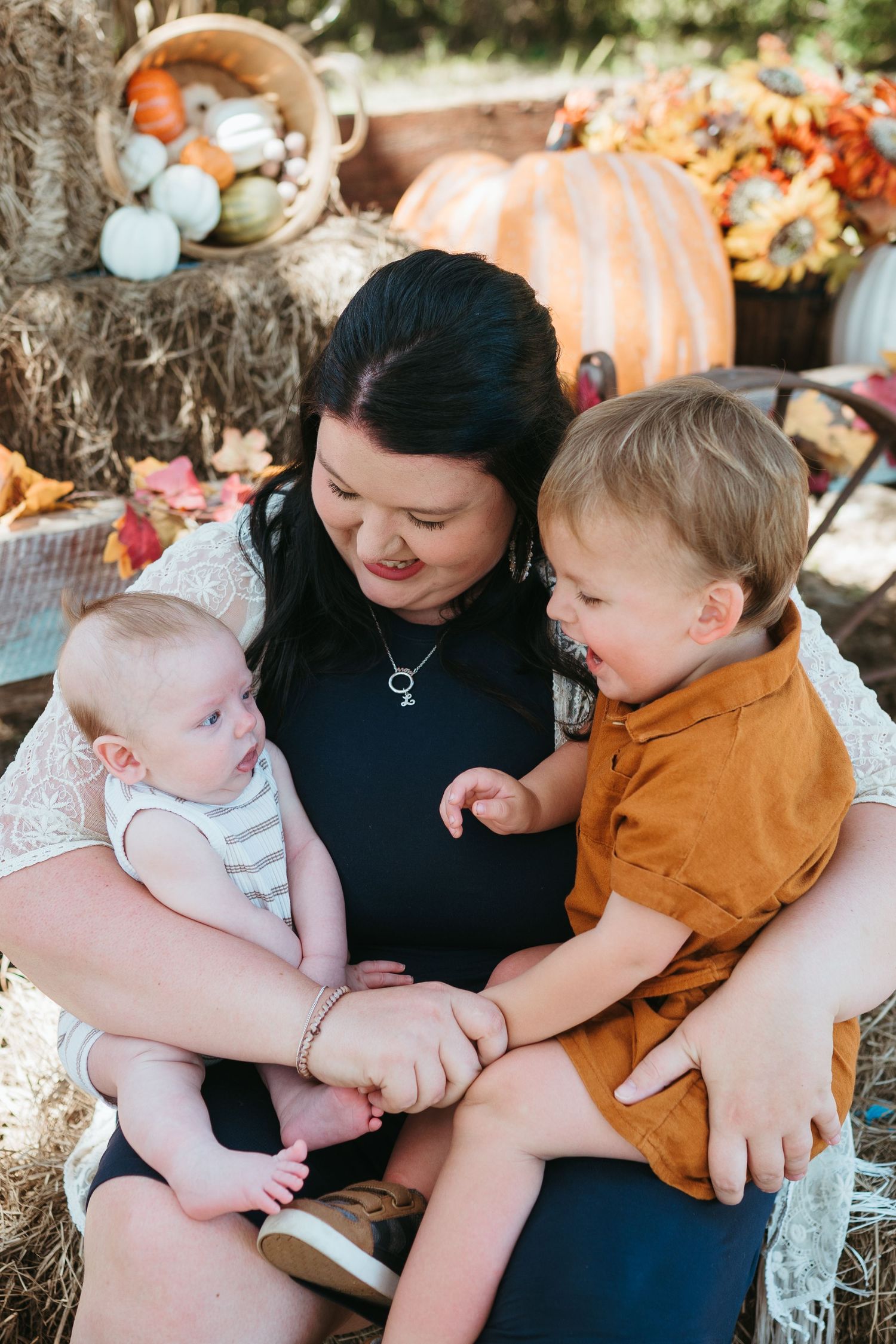 A mother embraces her two young boys during a fall photography session