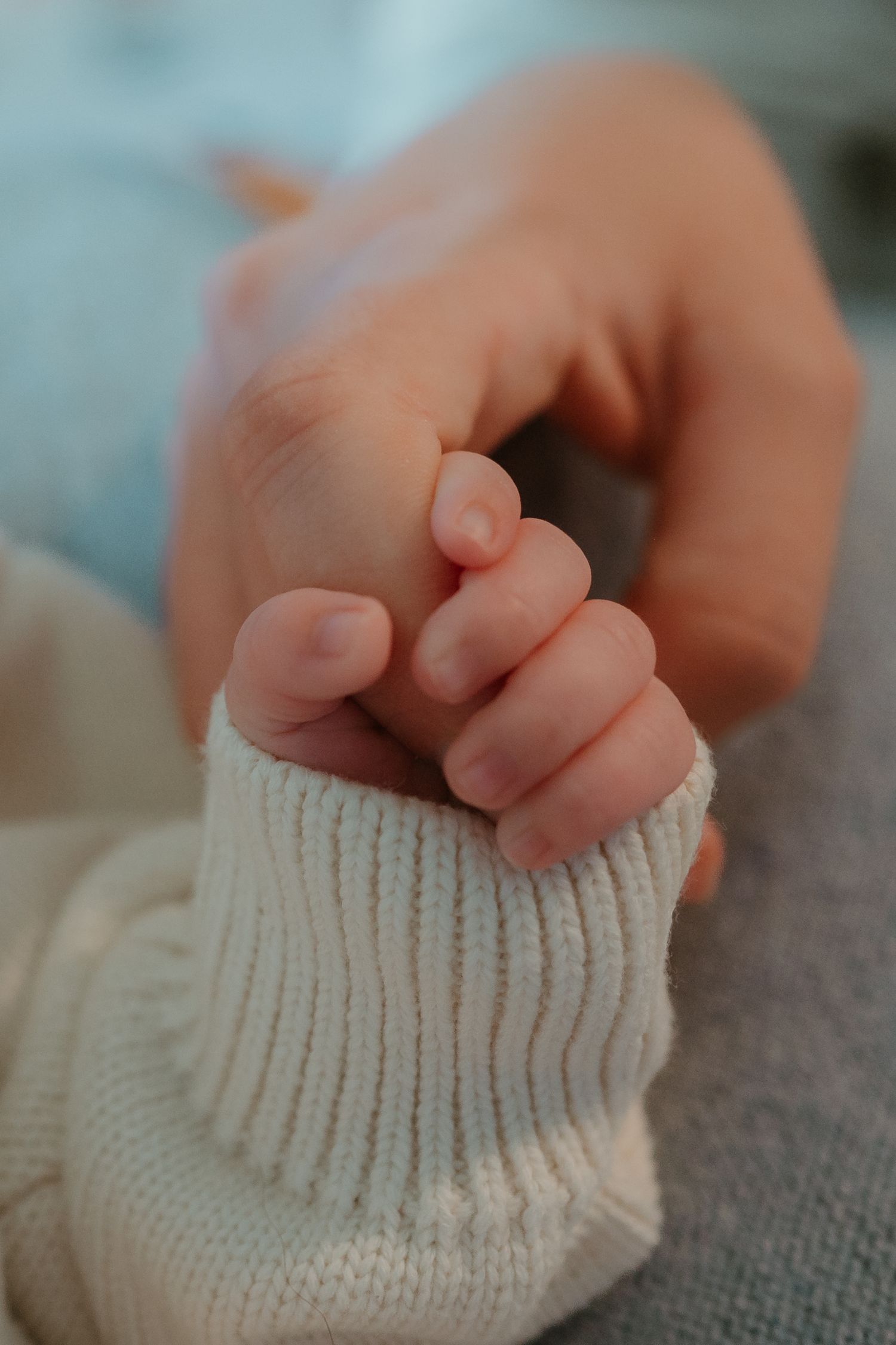 detail shot of a newborn baby gripping his mother's finger during a newborn in home session
