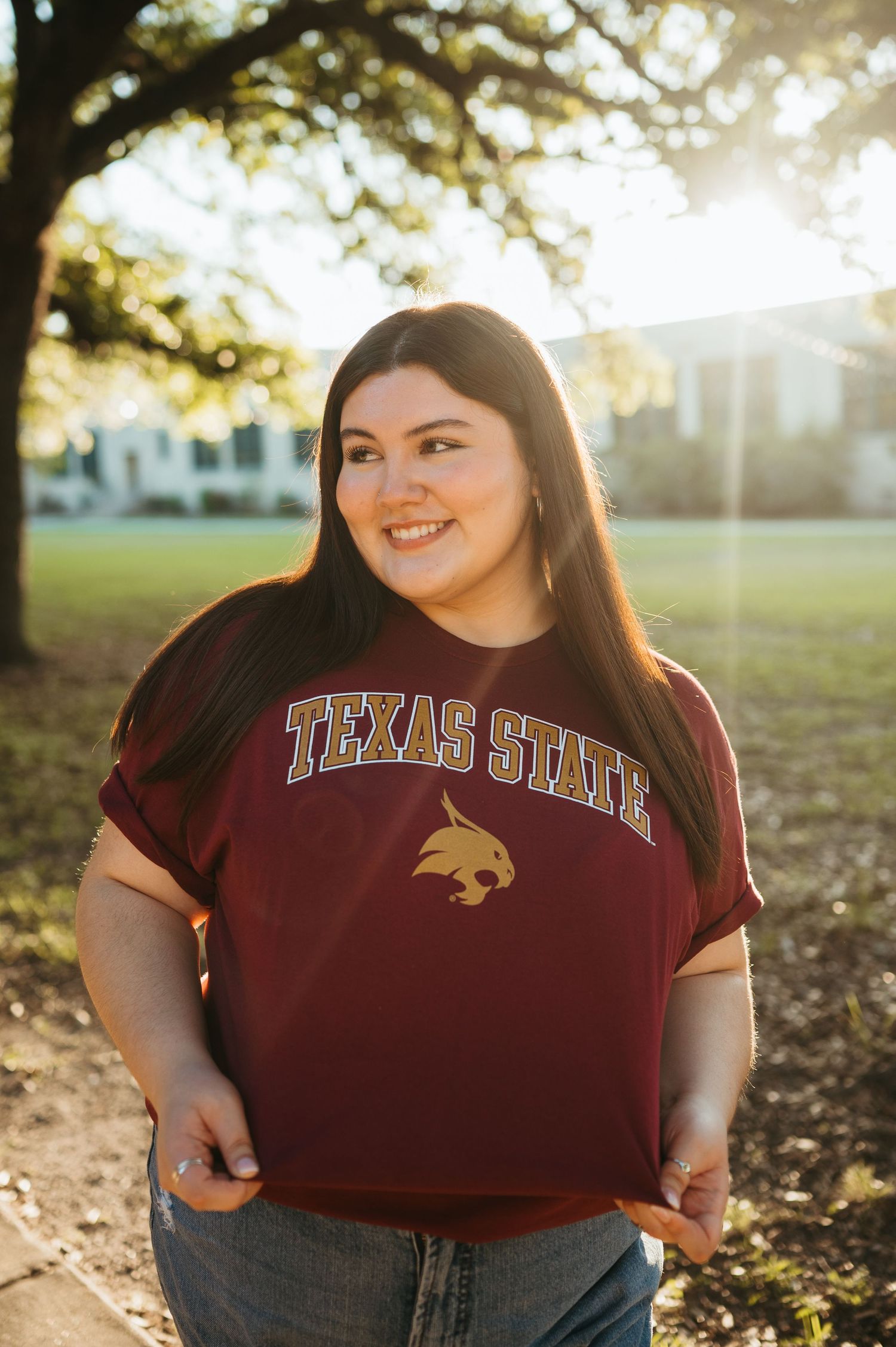 A senior proudly wears her Texas State University college tee during her senior photography session