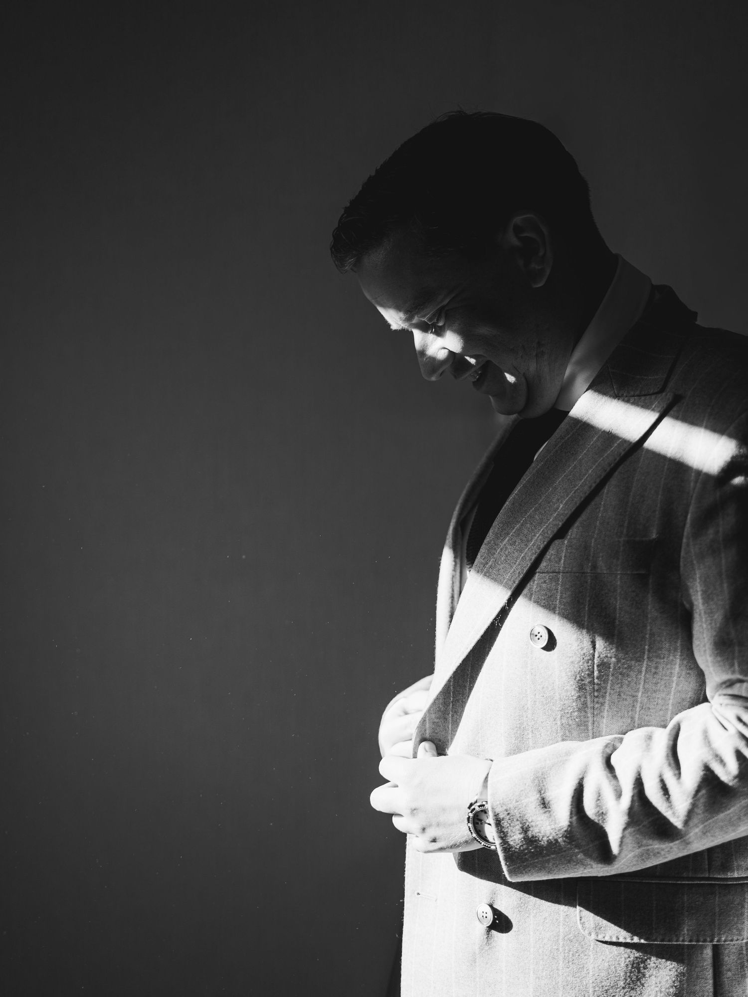 A series of black and white film noir style photographs showing dramatic lighting and shadows on a person in a suit.