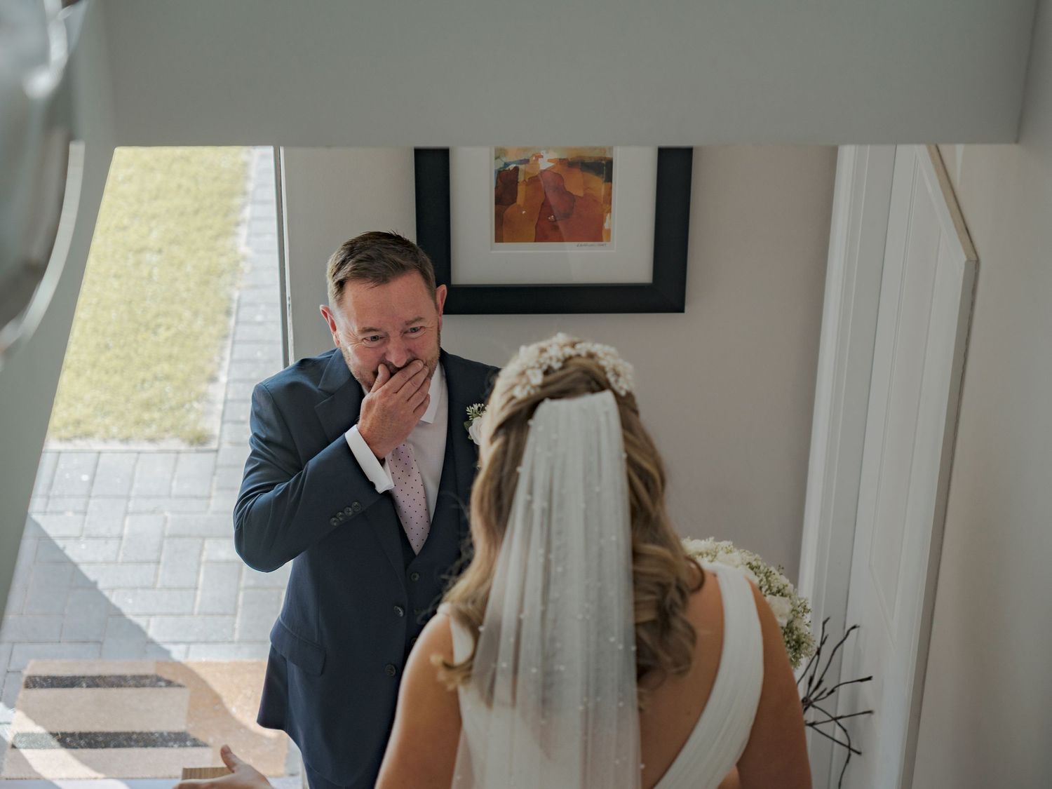A wedding photographer captures emotional reactions during a first look reveal at an indoor venue.
