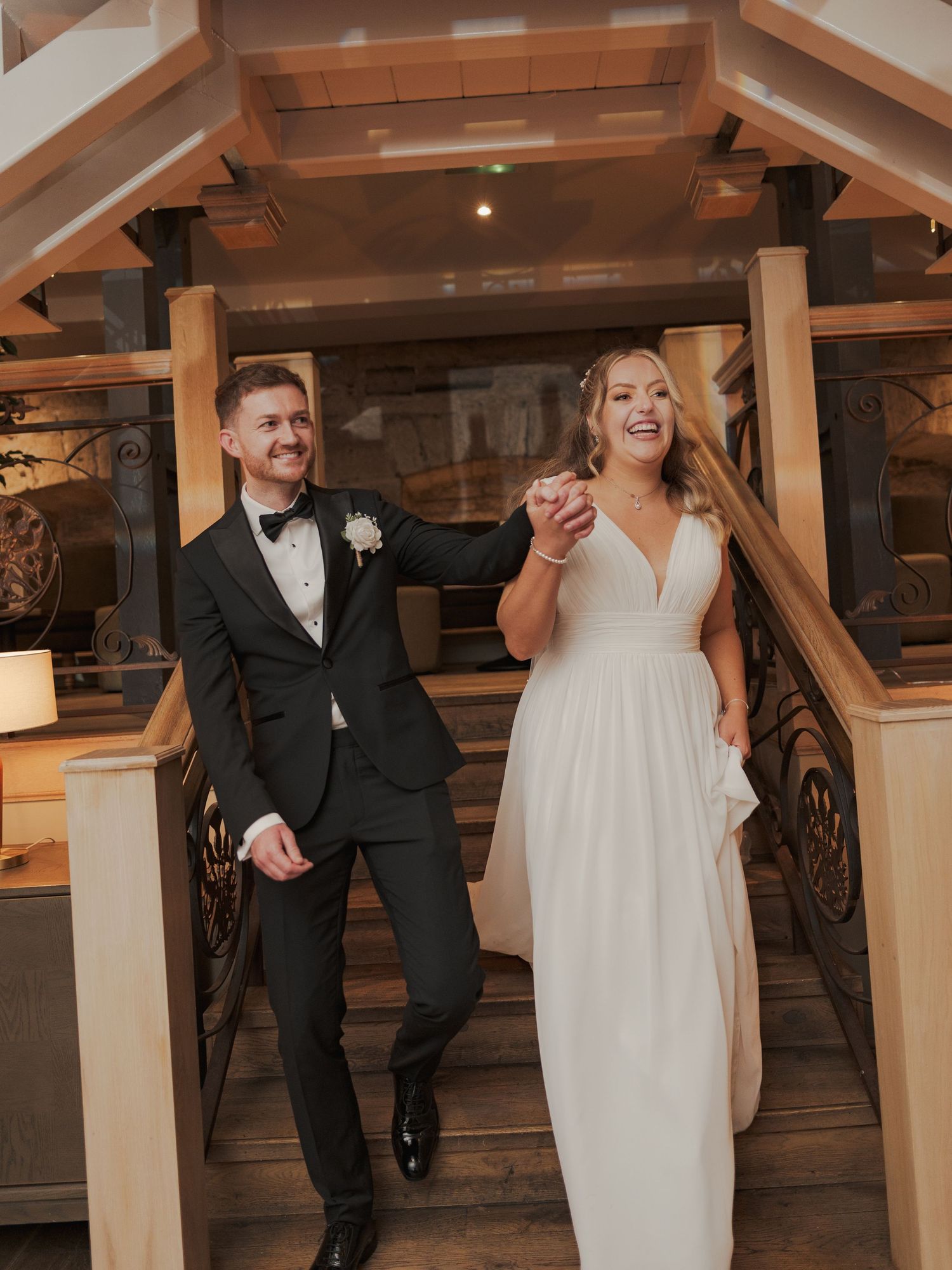 Wedding couple dances and laughs together in an elegant venue with wooden beams and warm lighting at Citation Glasgow.