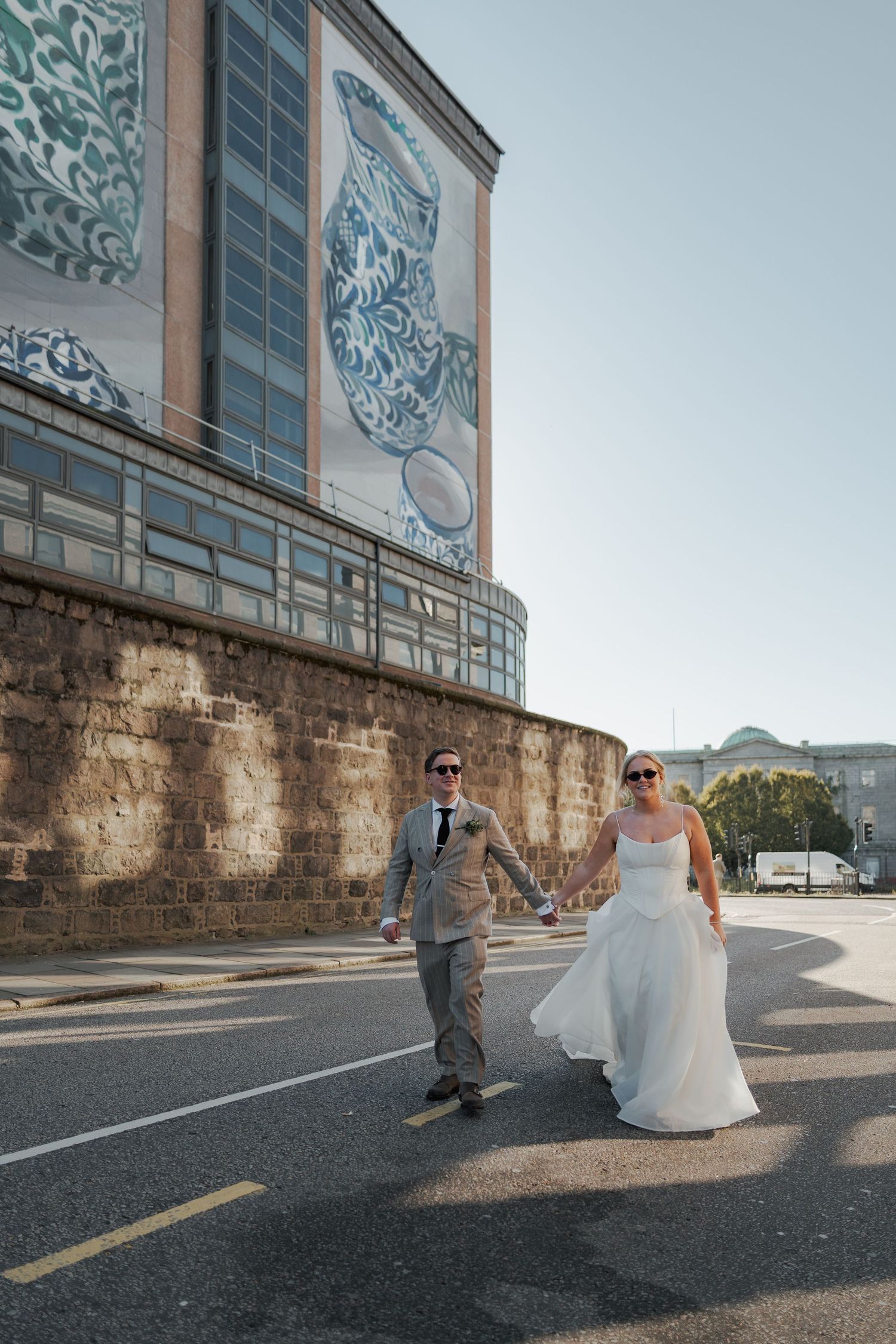 A series of wedding photos taken against an urban wall backdrop with a modern building design at the Sandman Signature, Aberdeen.