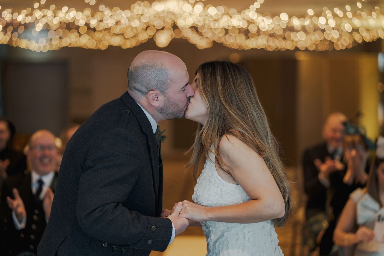 A sequence of romantic first dance moments at a wedding reception under warm glowing lights.