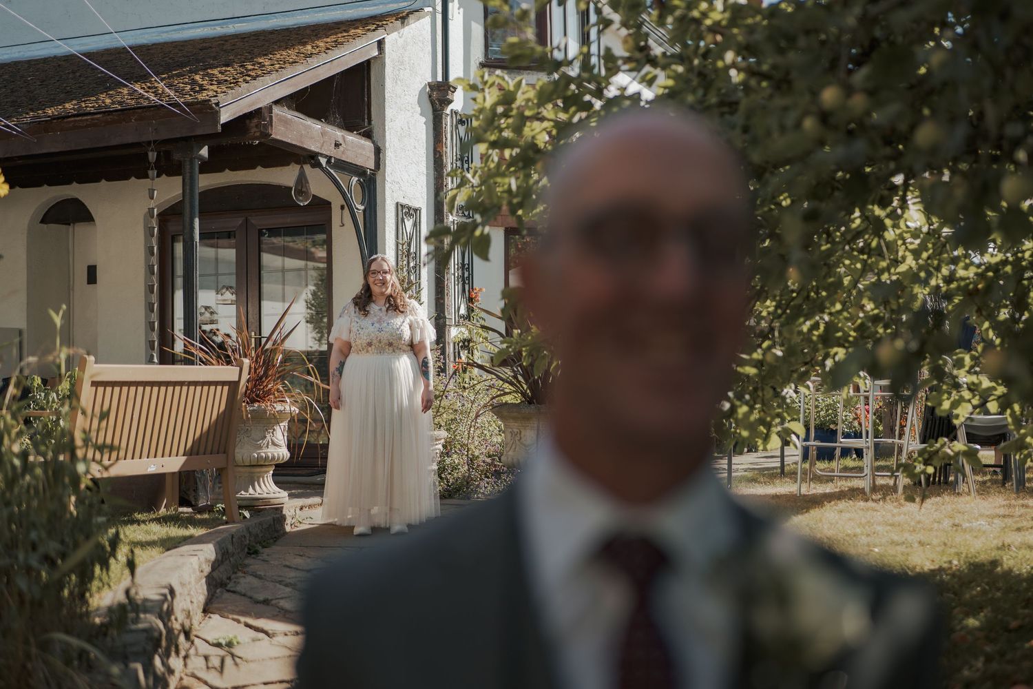 Four connected panoramic photos show a sun-drenched mountain resort lodge with rustic architecture and outdoor seating area.