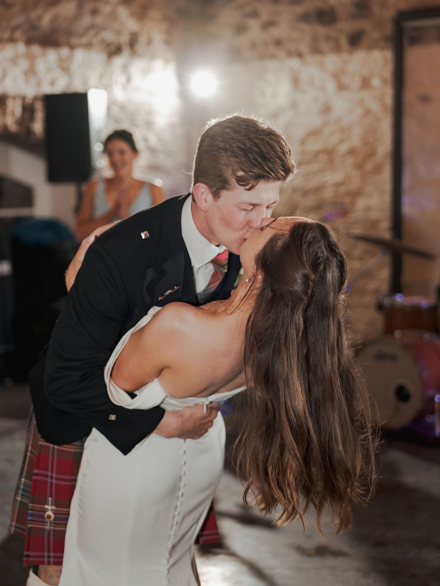 Bride and groom share a romantic dip kiss on the dance floor at a Scottish wedding reception.