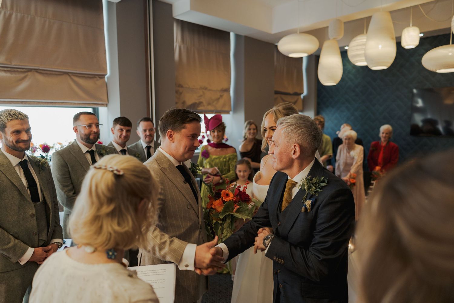 Elegant wedding reception venue decorated with white paper lanterns and filled with guests mingling and celebrating.