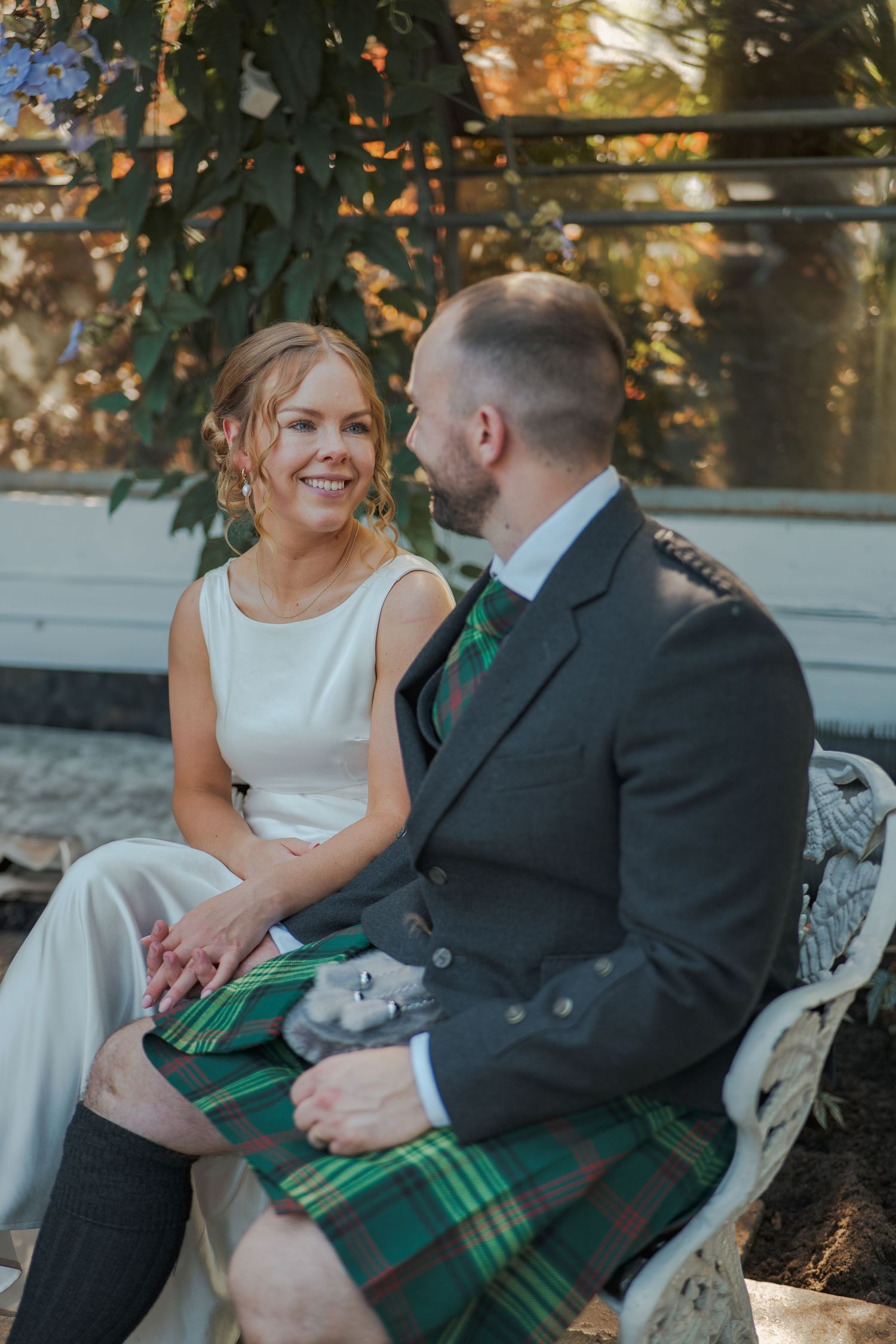 A couple sits together on a white bench at David Welsh Winter Gar dens