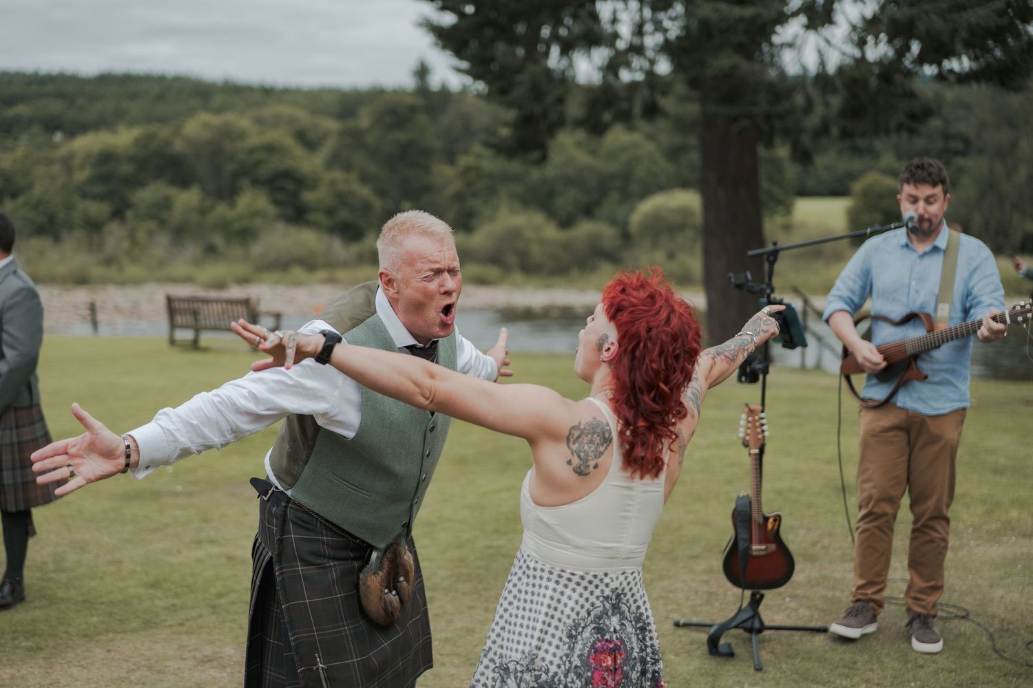 People enjoying outdoor games and activities at a scenic park setting with trees and a lake in the background at Banchory Lodge.