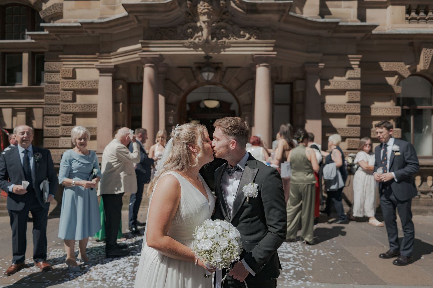 A romantic wedding moment captured outside 23 Montrose Street with classical architecture and columns.