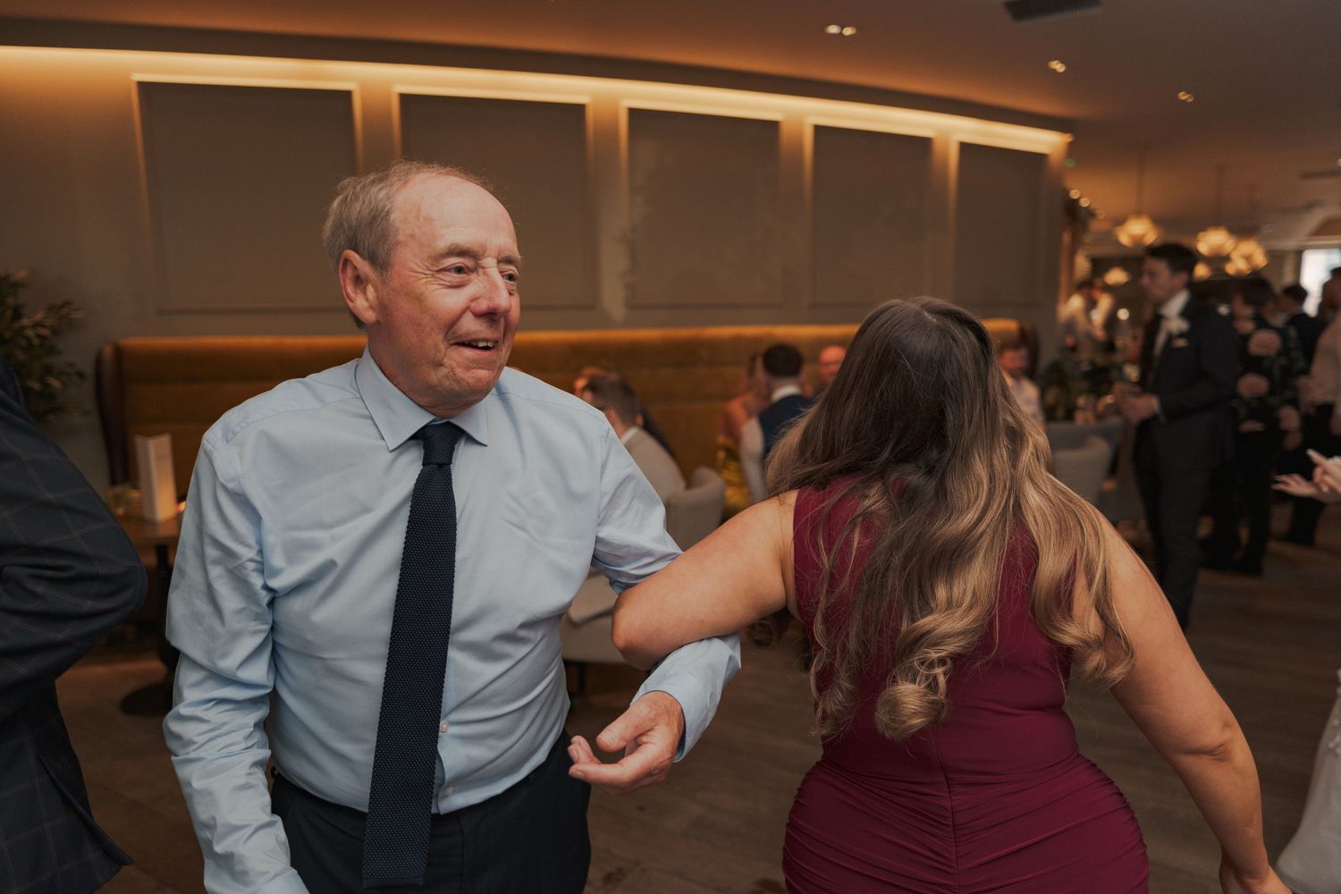 Wedding guests dance and celebrate on a lively reception dance floor.