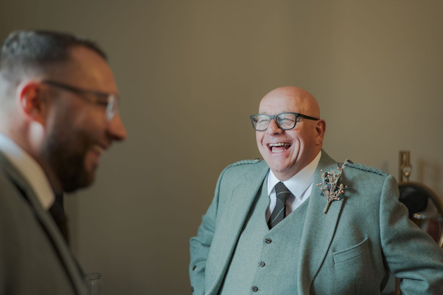 A sequence of candid shots showing people in light-colored suits chatting and smiling in an indoor setting at Banchory Lodge.