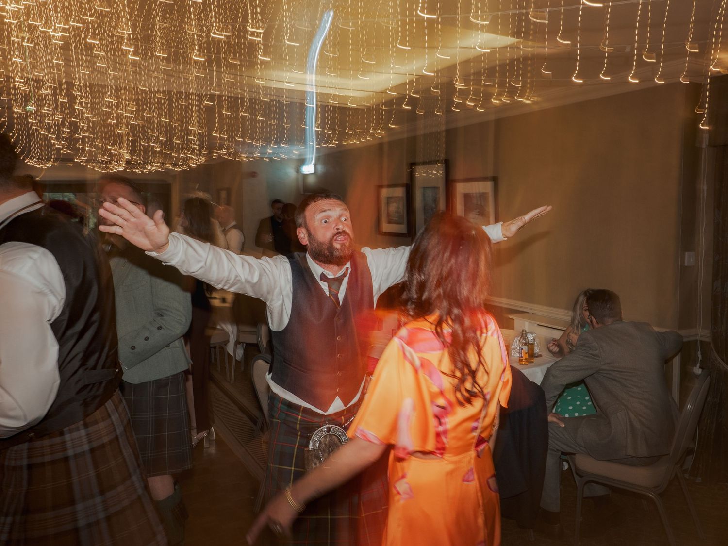 A crowded dance party scene with disco lighting and people dancing in an indoor venue.