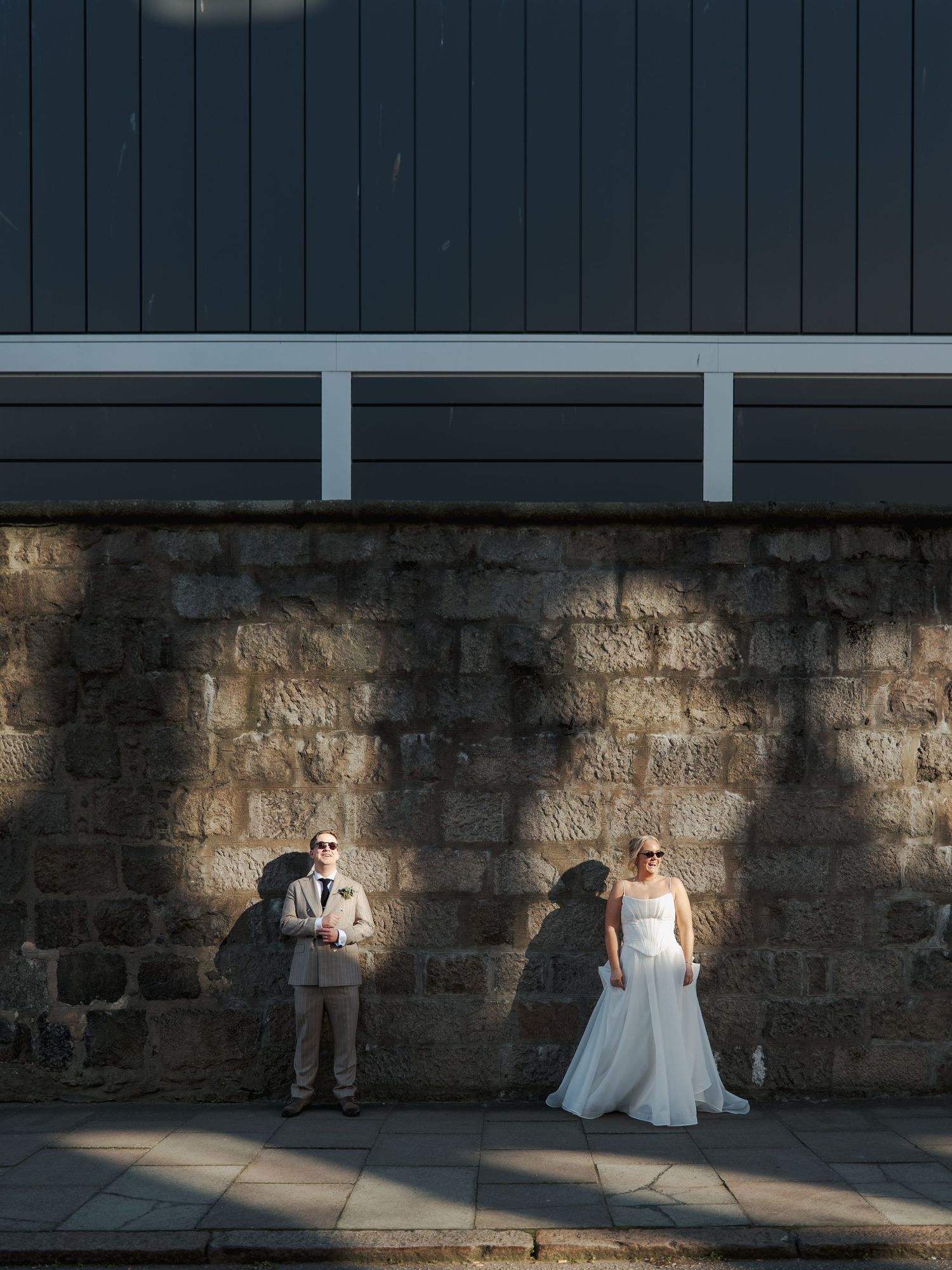 A sequence of romantic wedding portraits against a dark stone wall with dramatic lighting and shadows.