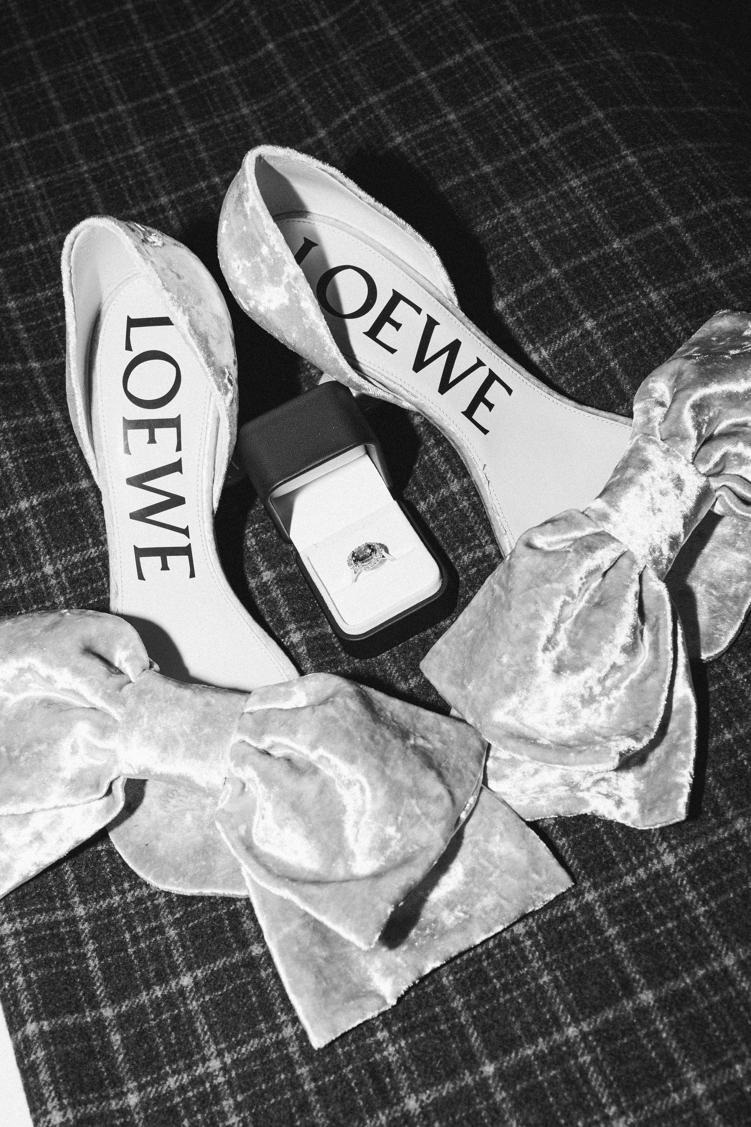 Black and white photograph showing torn pieces of paper with fragments of text letters scattered on a textured surface.