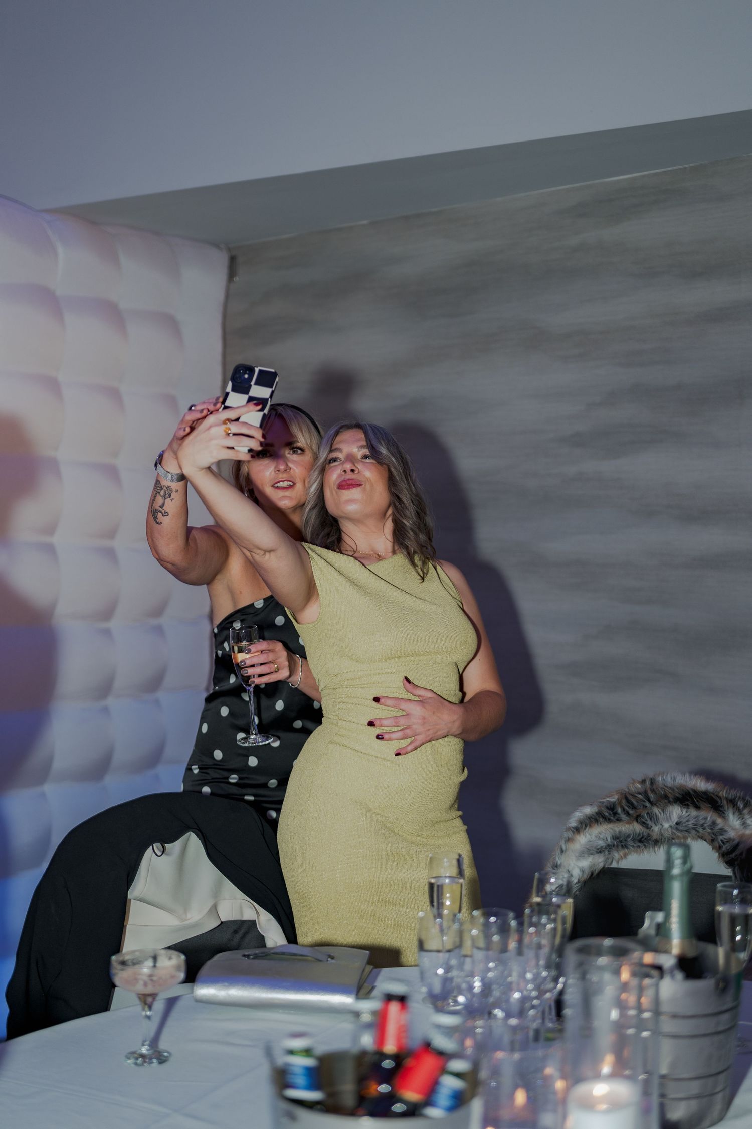 Guests enjoying drinks and socializing at a dimly lit party venue with white decor at the Sandman Signature, Aberdeen.