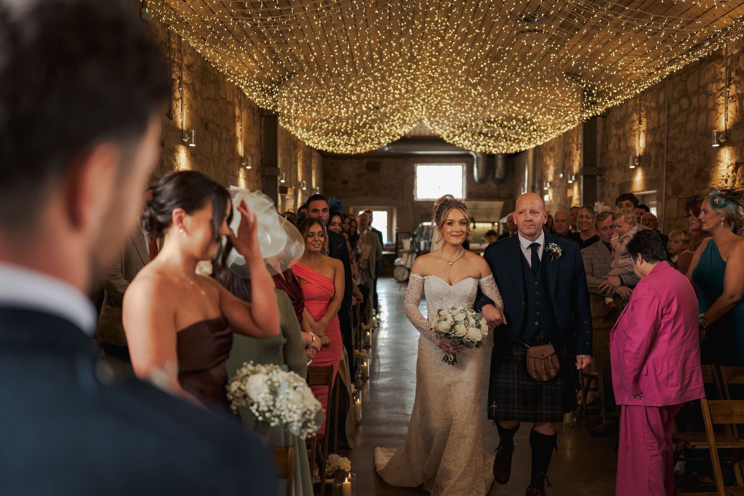 A wedding reception sequence showing guests dancing and celebrating under elegant crystal chandeliers.