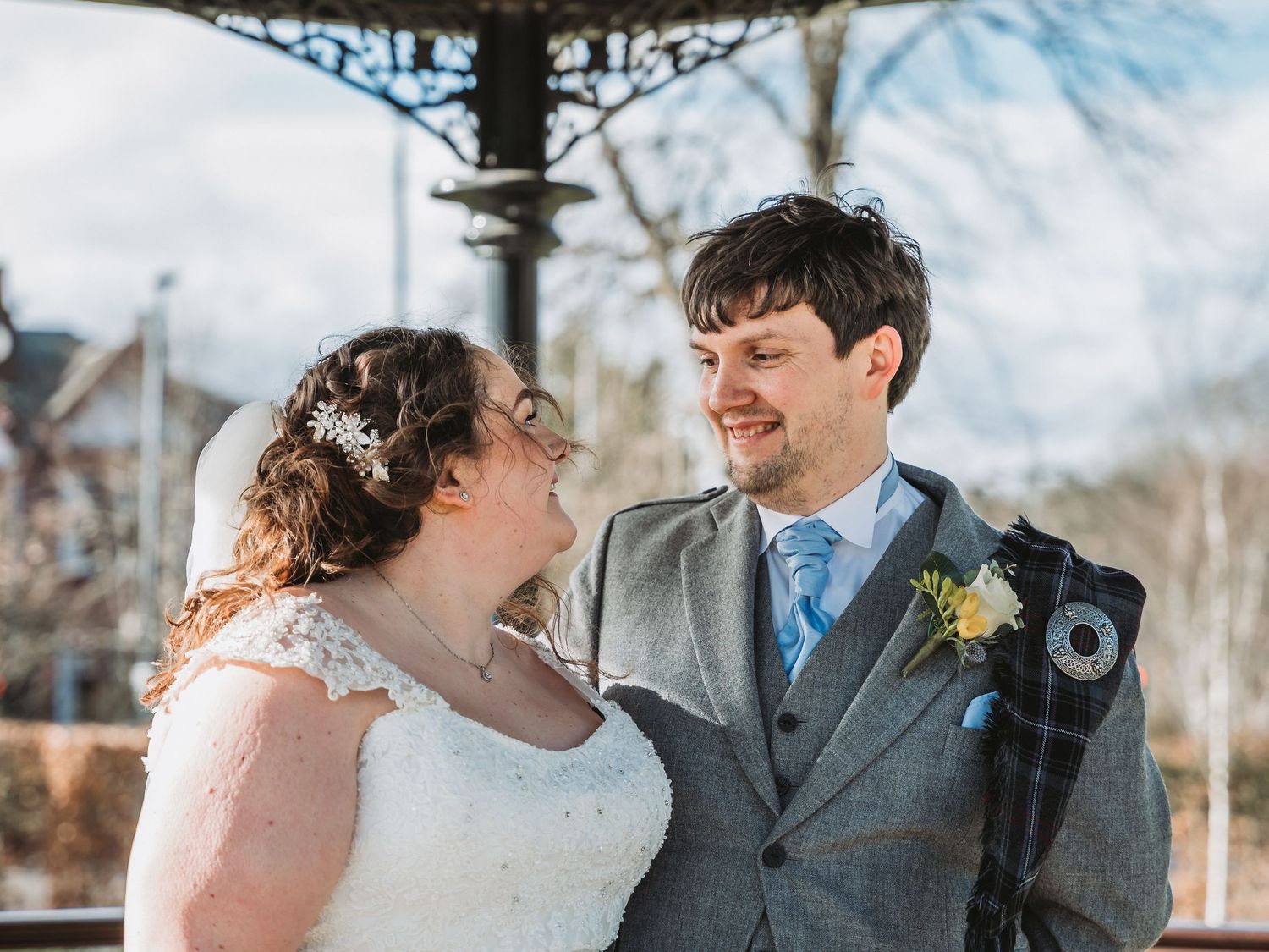 Joyful couple shares a loving moment while wearing traditional wedding attire outdoors at Boclair House.