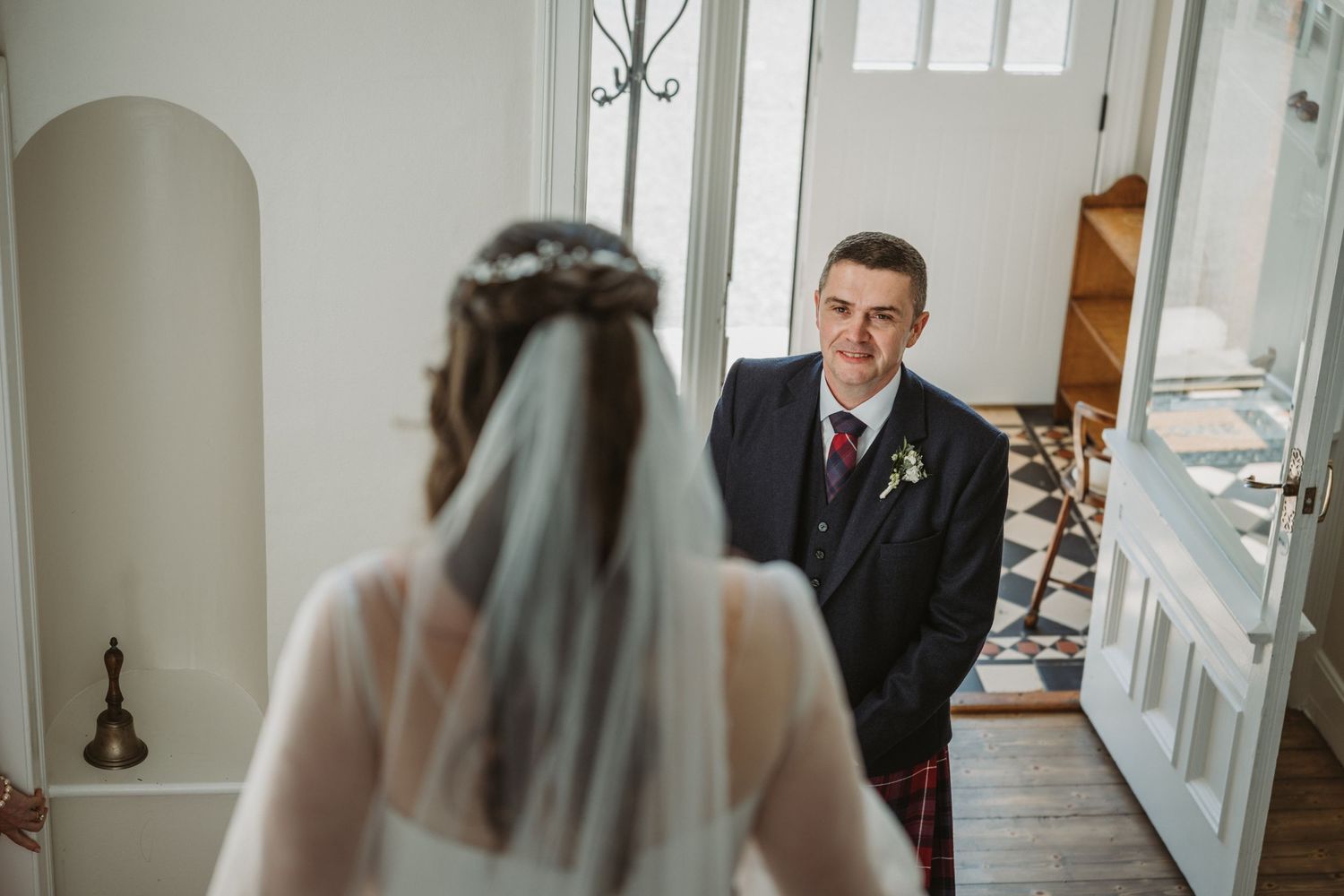 A tender first look moment between the bride and her father on the grand stairs of Kinclune House