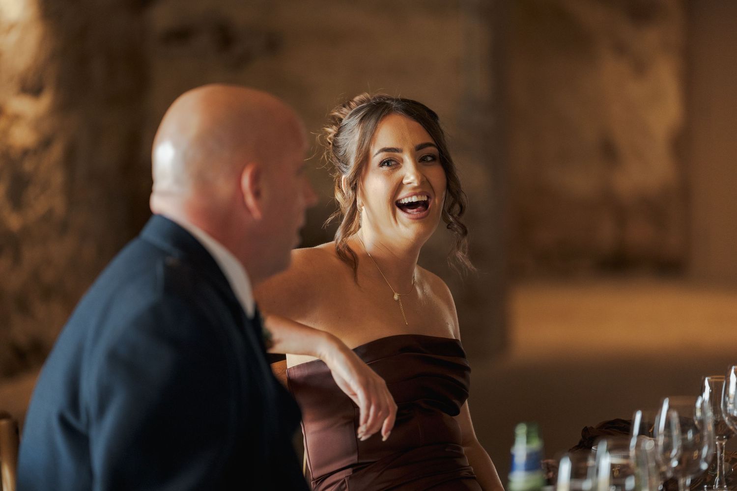 Guests enjoying an elegant indoor reception with warm lighting and table settings at a formal event.