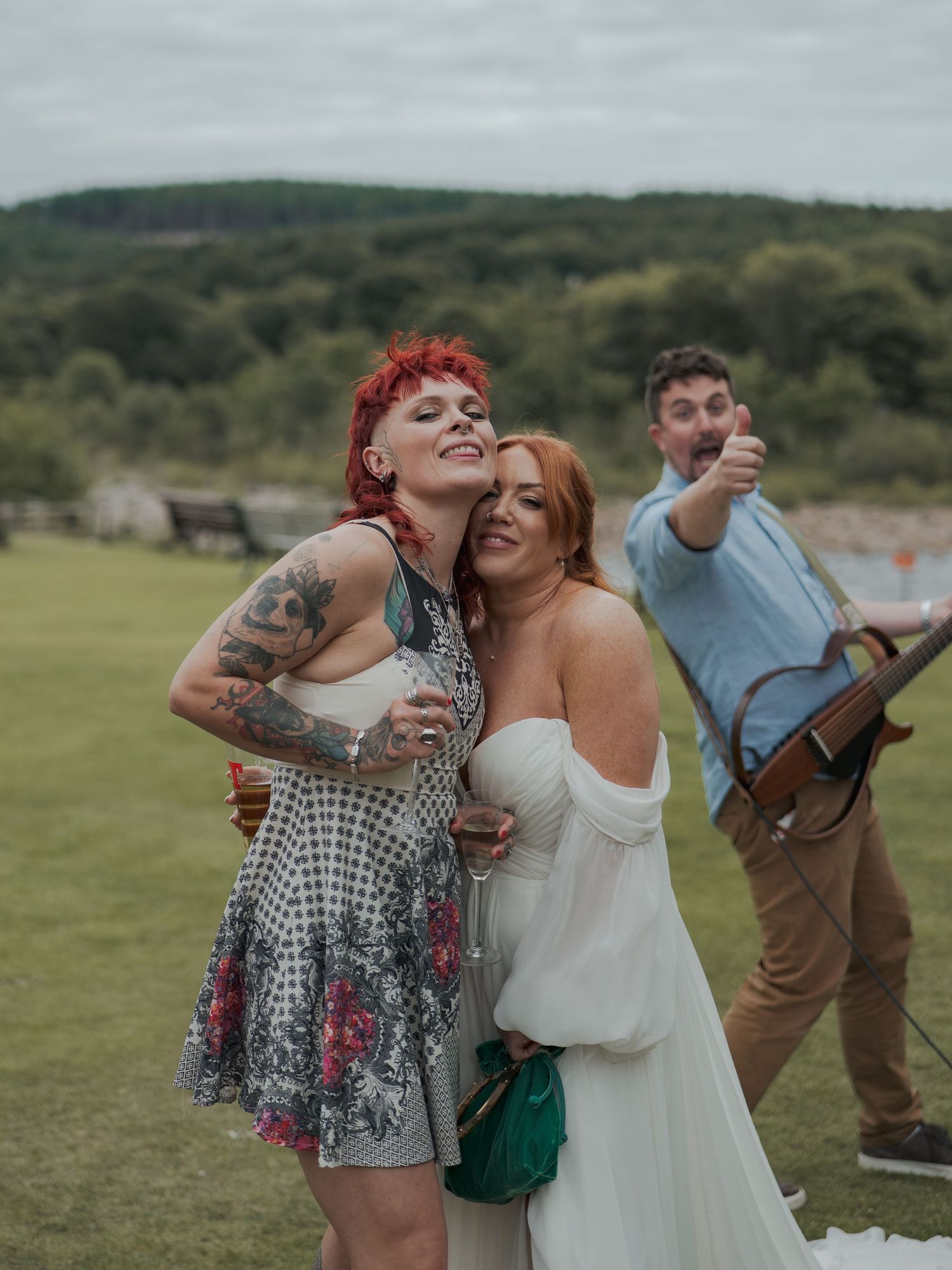 People laughing and embracing joyfully together in an outdoor field setting during what appears to be a celebration.