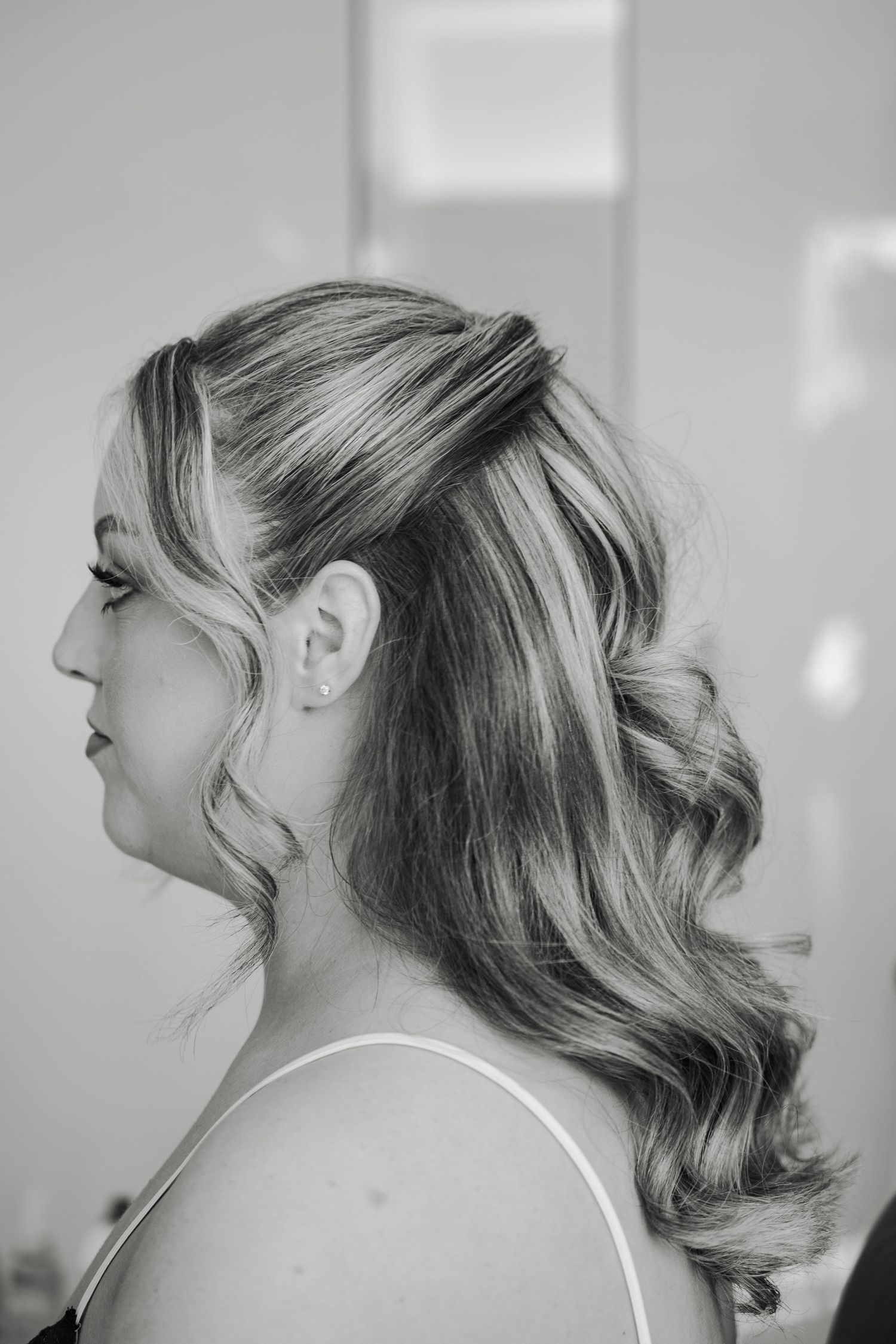 Side profile views of a blonde updo hairstyle with soft waves and loose tendrils framing the face.