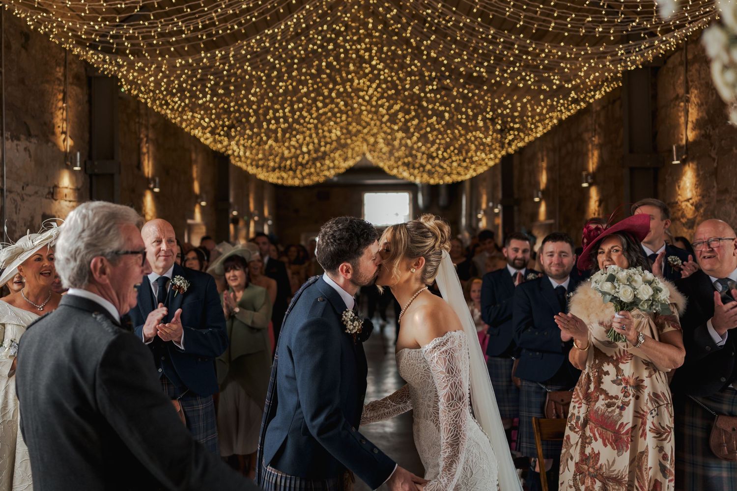 Wedding guests dance under a magical canopy of twinkling string lights at an elegant evening reception celebration at Falside Mill.