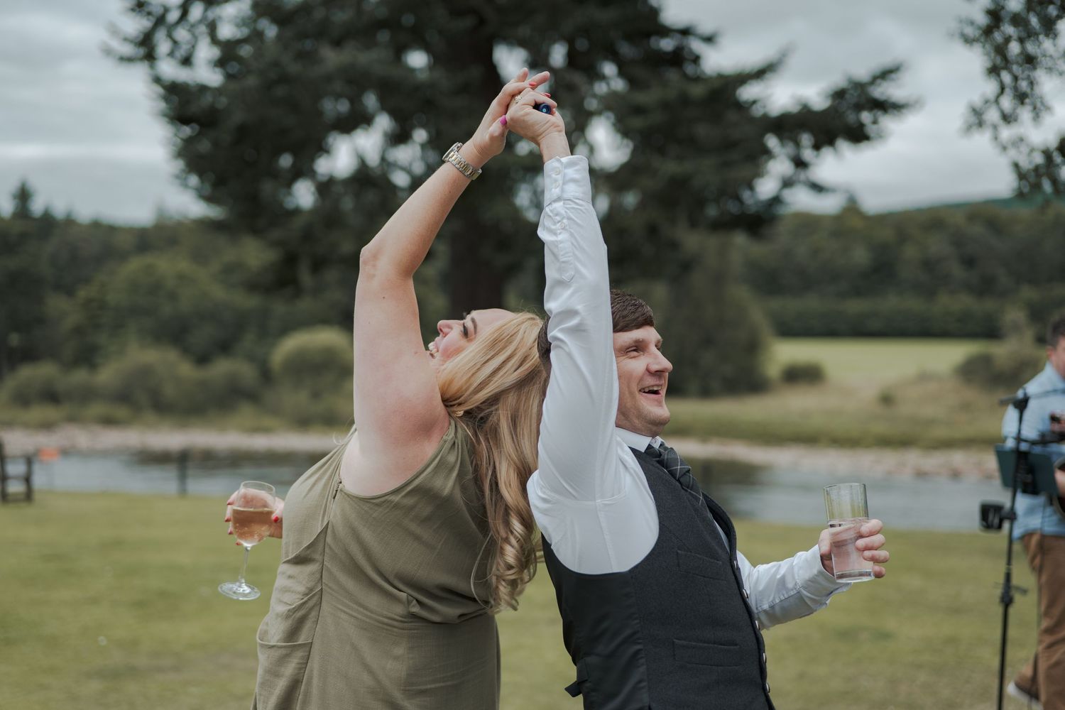 Group playing lawn games and socializing at an outdoor gathering near a lake surrounded by nature at Banchory Lodge.