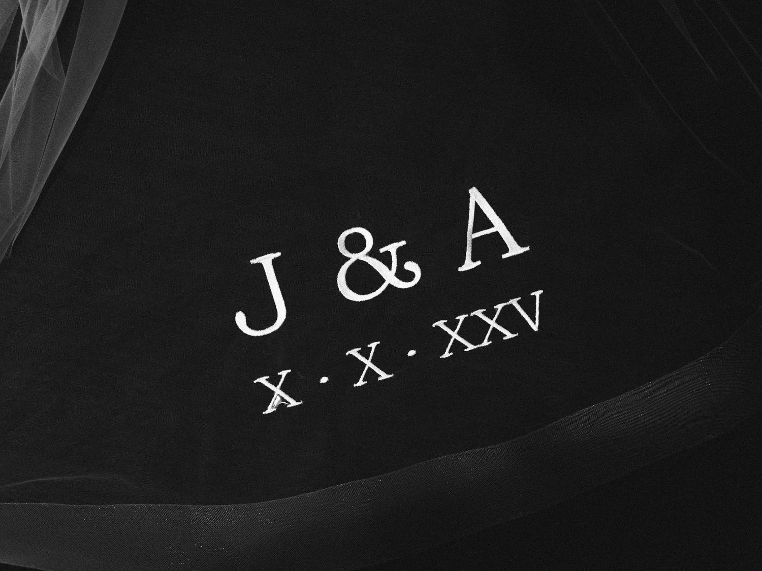 Decorative text and lettering details in white against a dark background with elegant calligraphic style.
