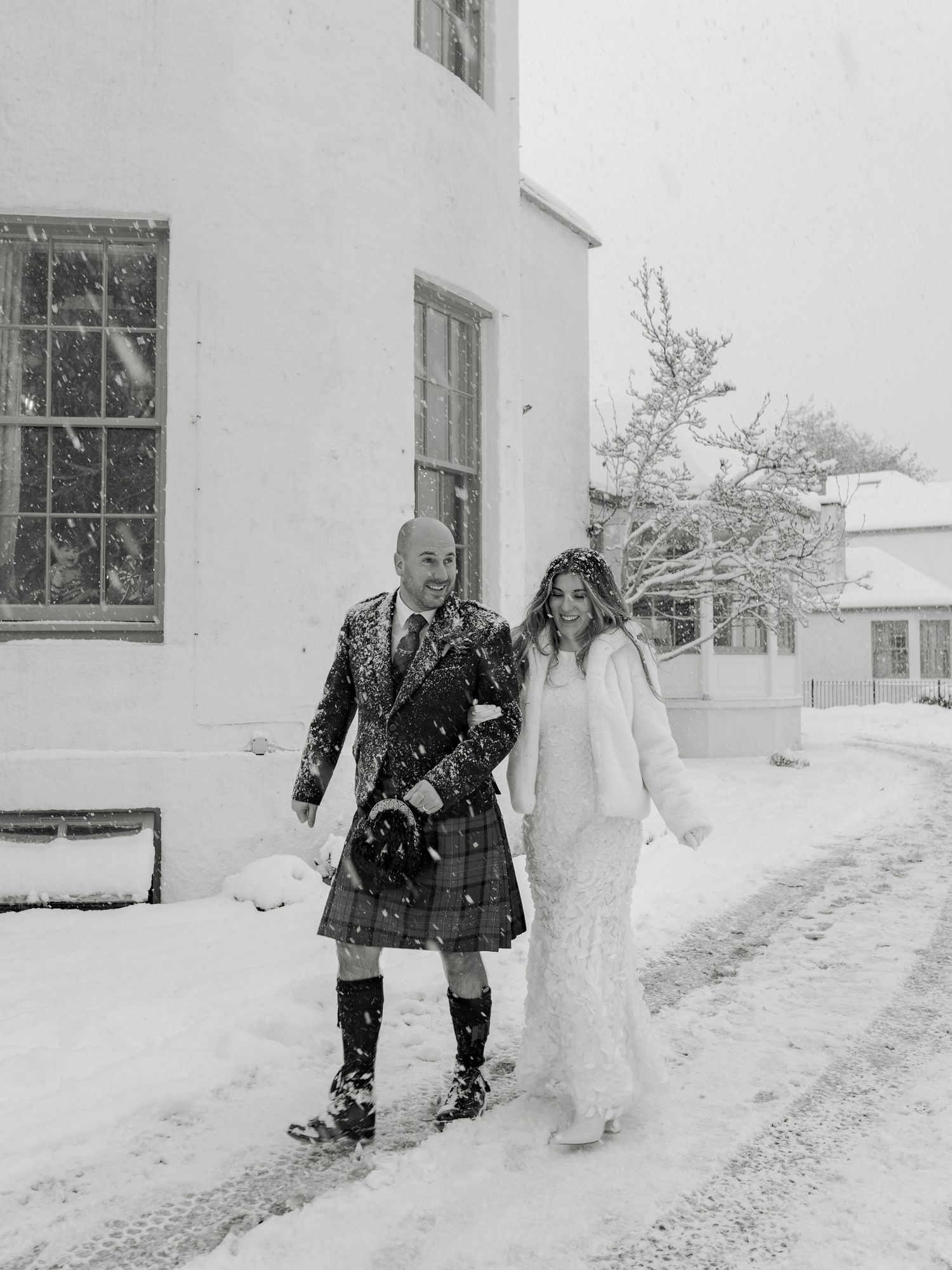 A sequence of black and white photos shows people and a snowman in a snowy winter landscape by a house.