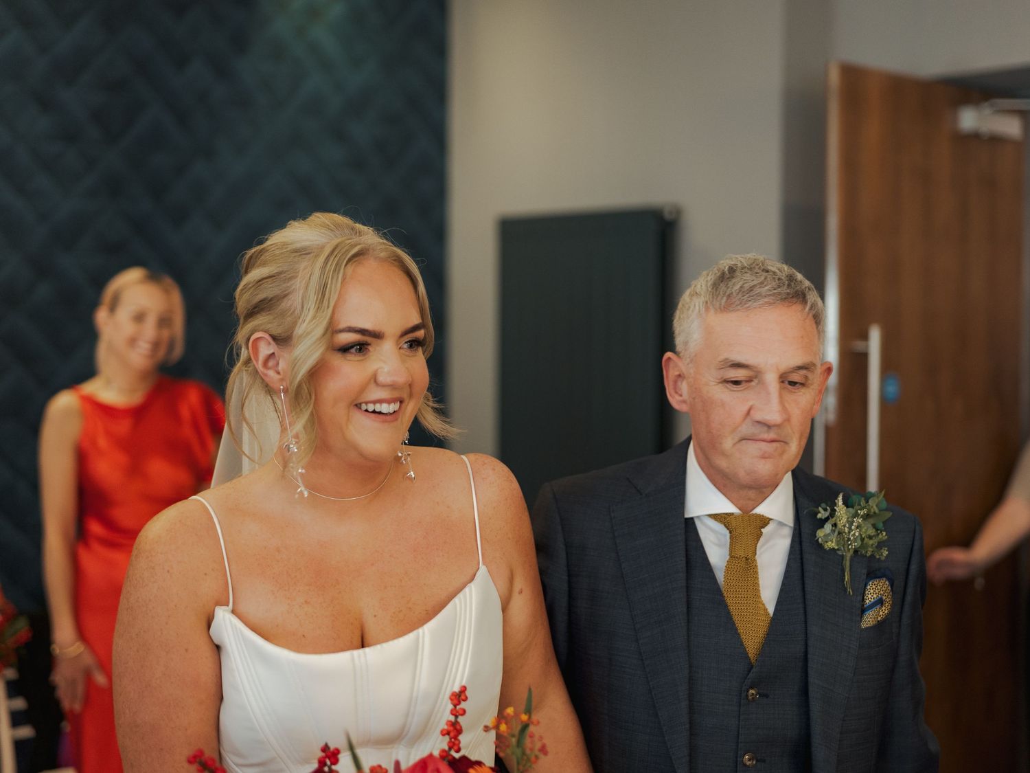 A joyful wedding reception scene shows guests dancing and celebrating together in an indoor venue.