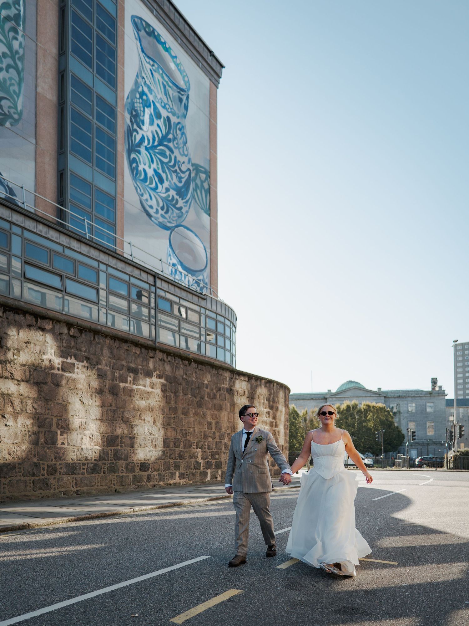 A series of wedding photos showing a couple walking along a stone wall during golden hour.