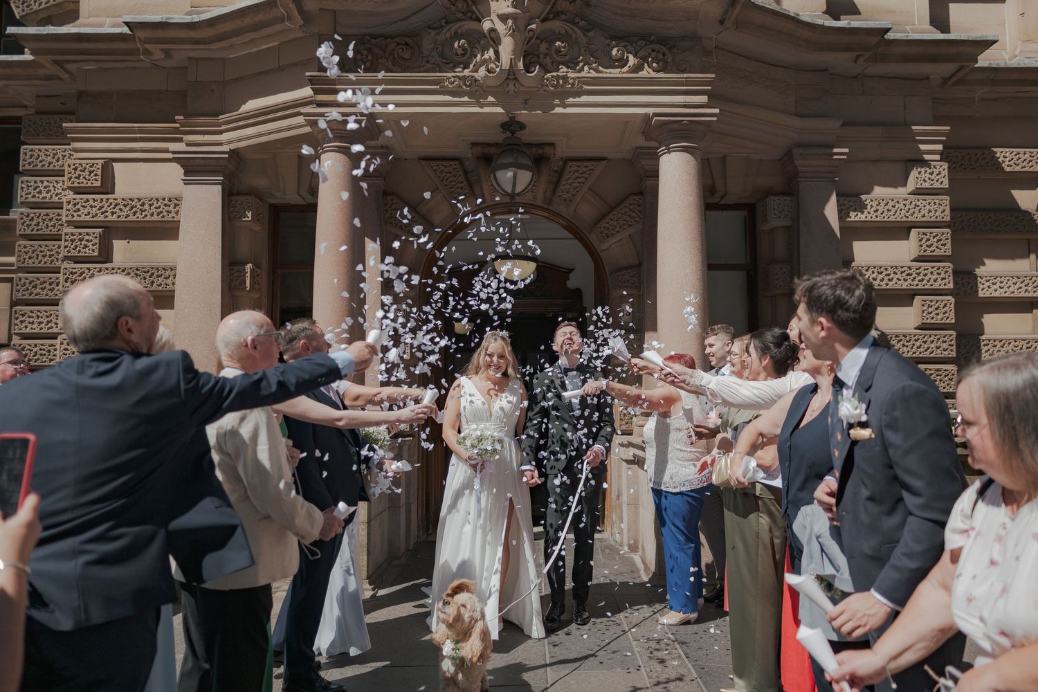 Wedding guests celebrate by throwing confetti at the entrance of 23 Montrose Street.