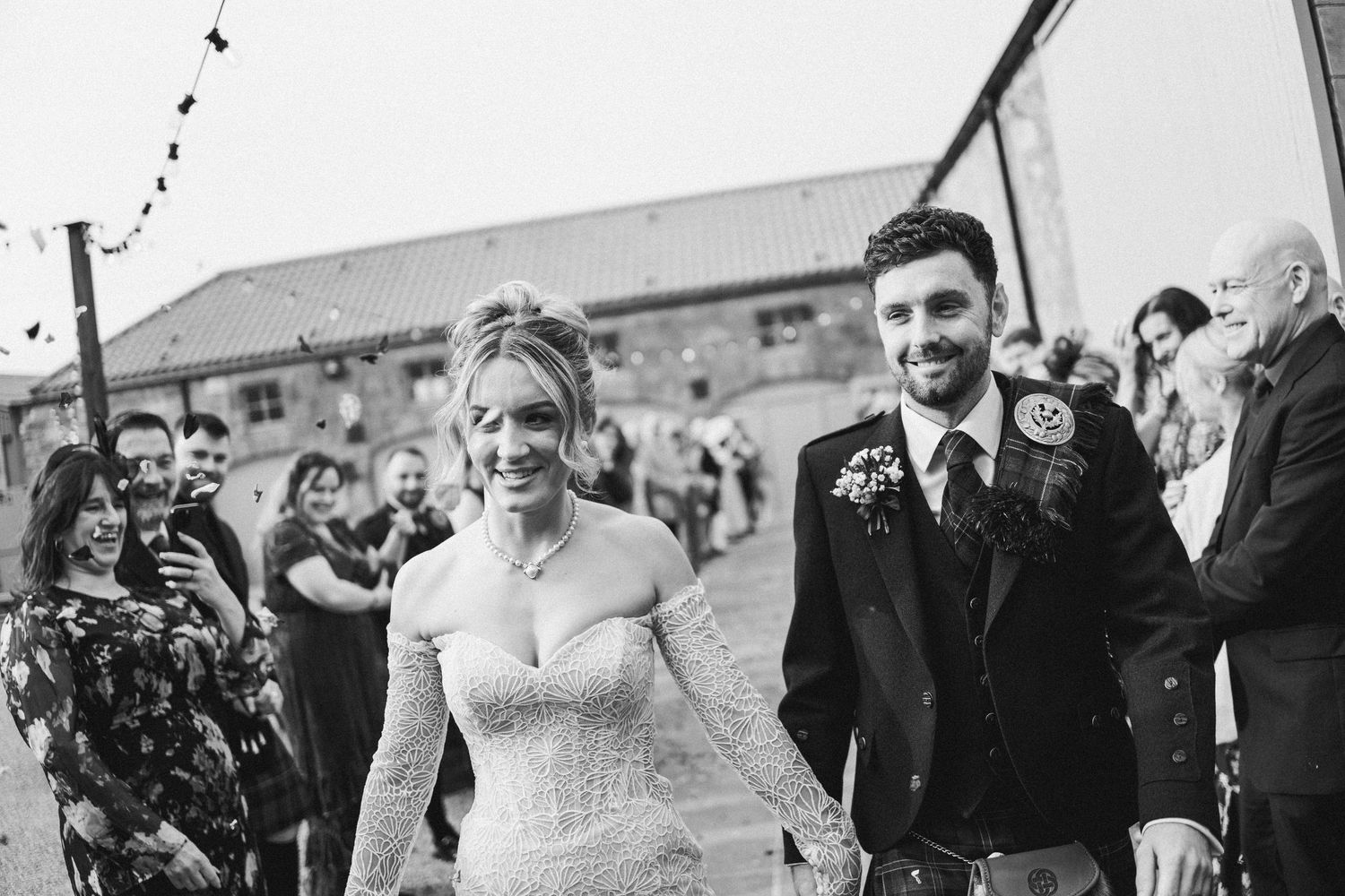 A black and white collage of wedding moments showing dancing, embraces and celebrations at a reception.