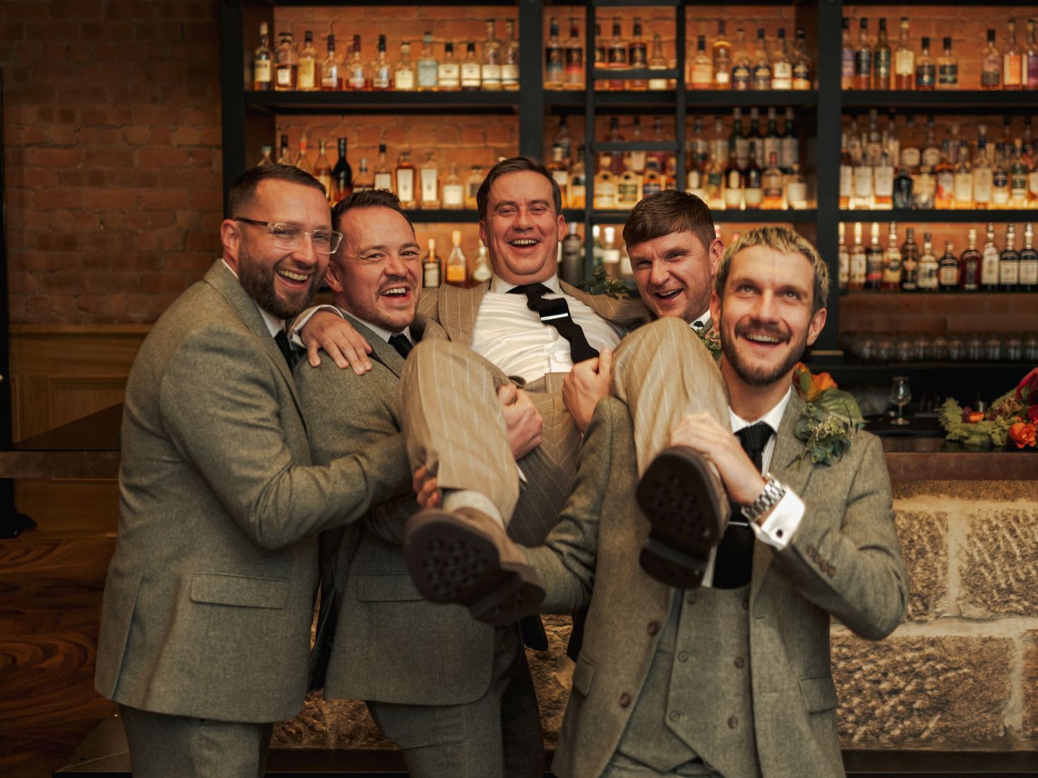 Sequence of candid photos showing groomsmen laughing and sharing joyful moments at the Sandman Signature, Aberdeen.