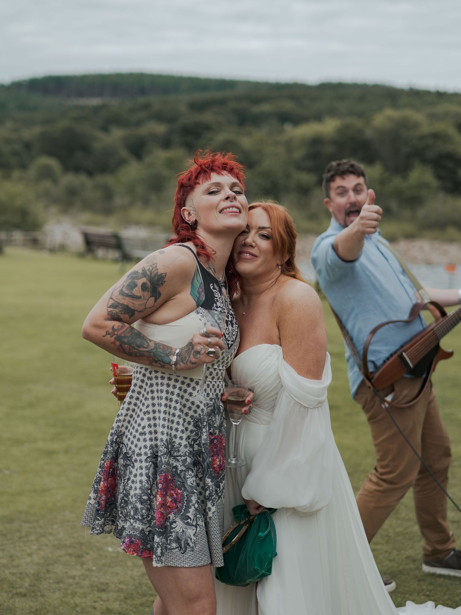 Two friends in festive attire sharing playful moments and laughter at an outdoor celebration at Banchory Lodge.