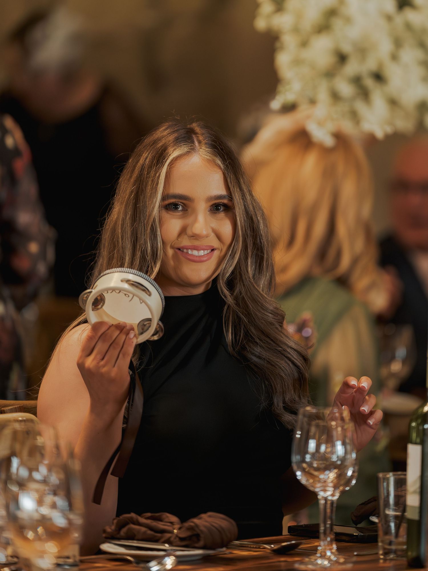 Guest enjoying dessert at an intimate wedding reception dinner with wine glasses and table decor.