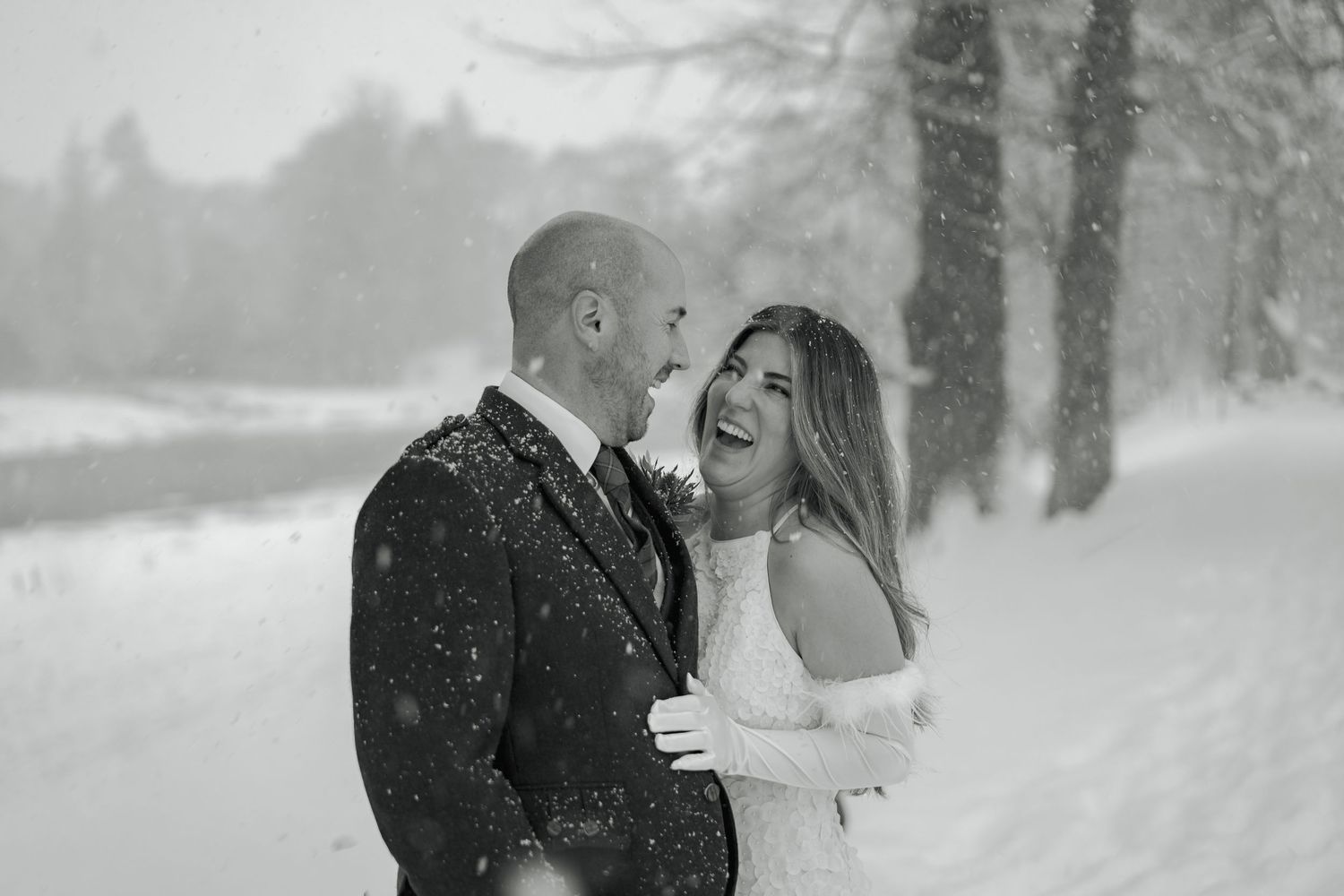 A couple shares a romantic moment in the snow during a winter engagement photo session.