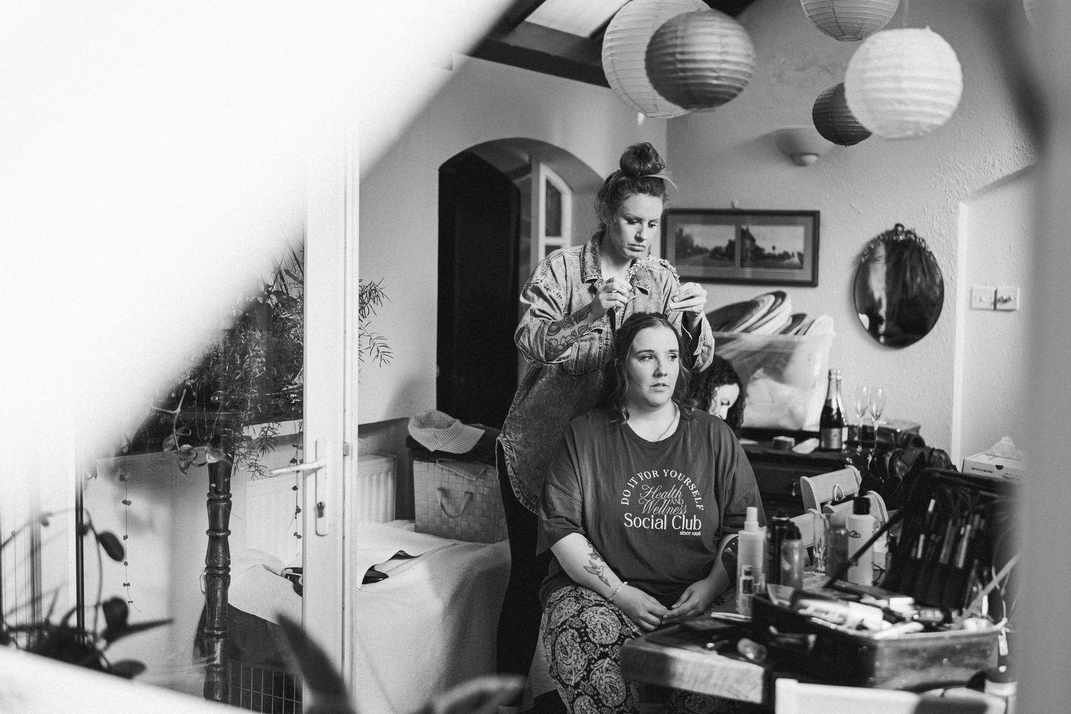 Hair styling session in progress at a cozy home salon with paper lantern decor and vintage style surroundings.