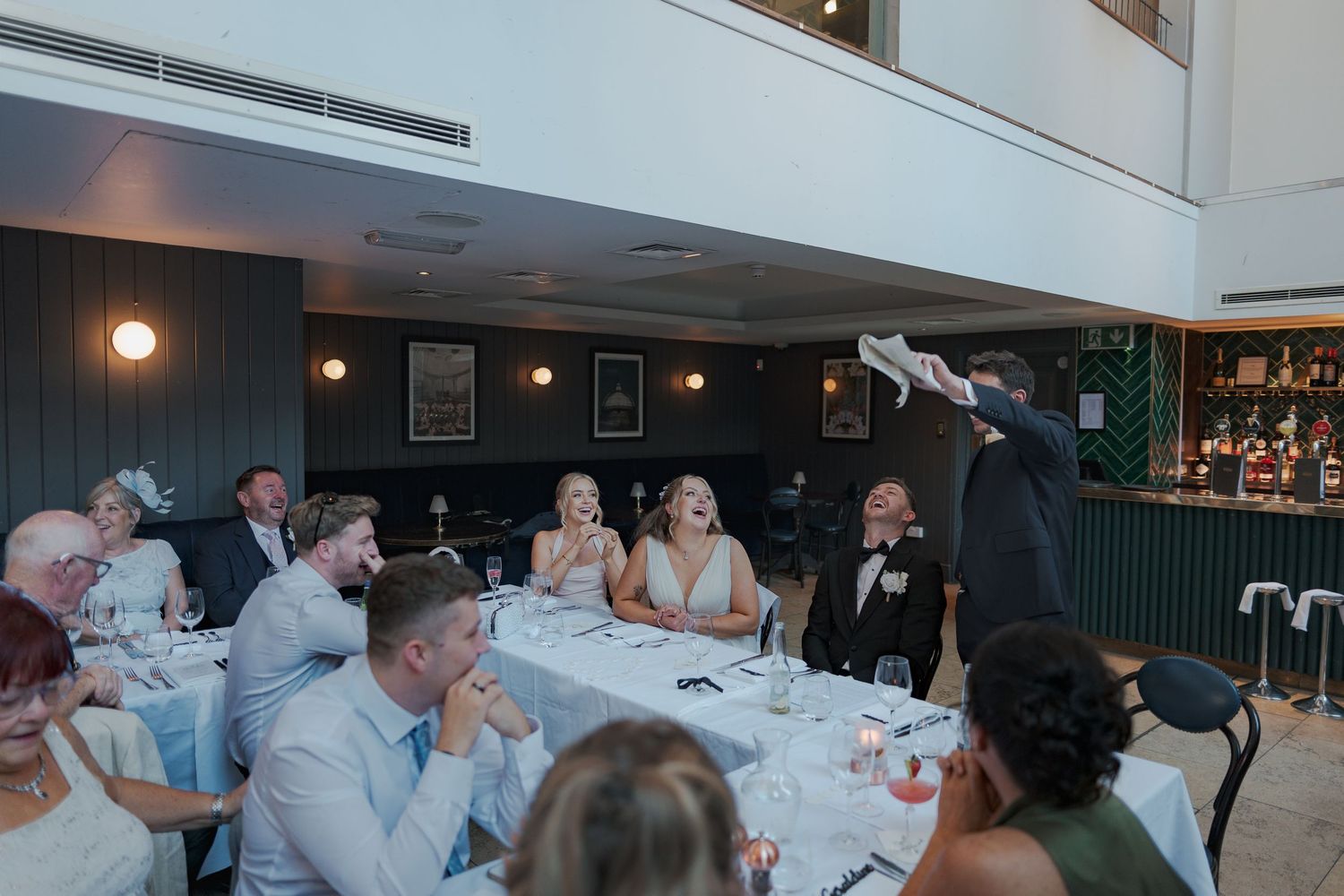 Wedding guests dance and celebrate together on a dimly lit dance floor at an evening reception.