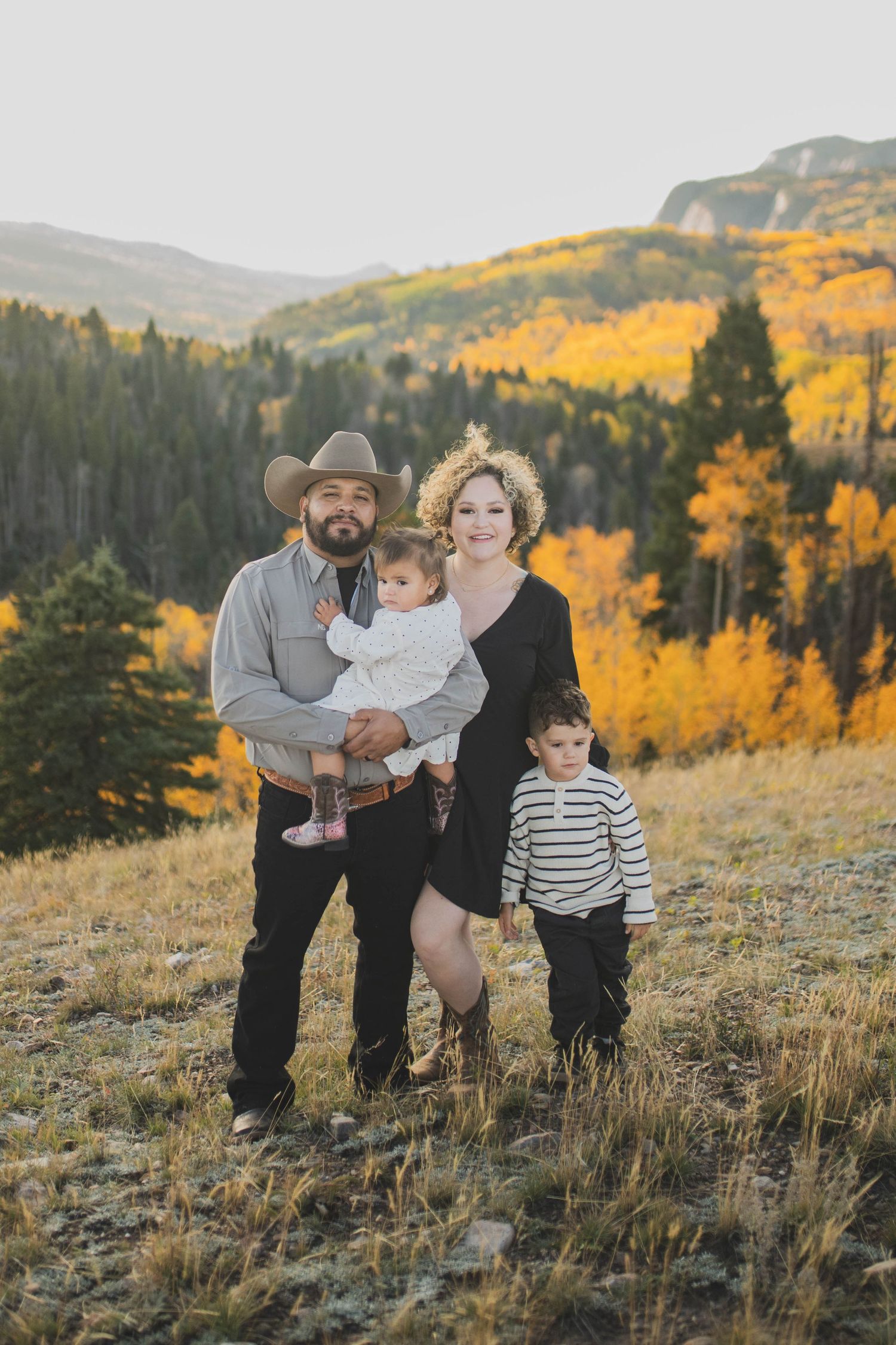 Formal autumn portrait of parents with toddlers in golden light — composed family photo by Quiet Light by The Amoras in New Mexico.
