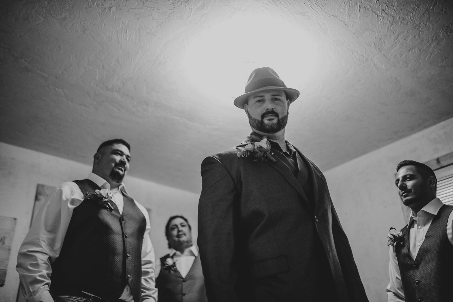 Dramatic black and white photo of formally dressed people in a room.