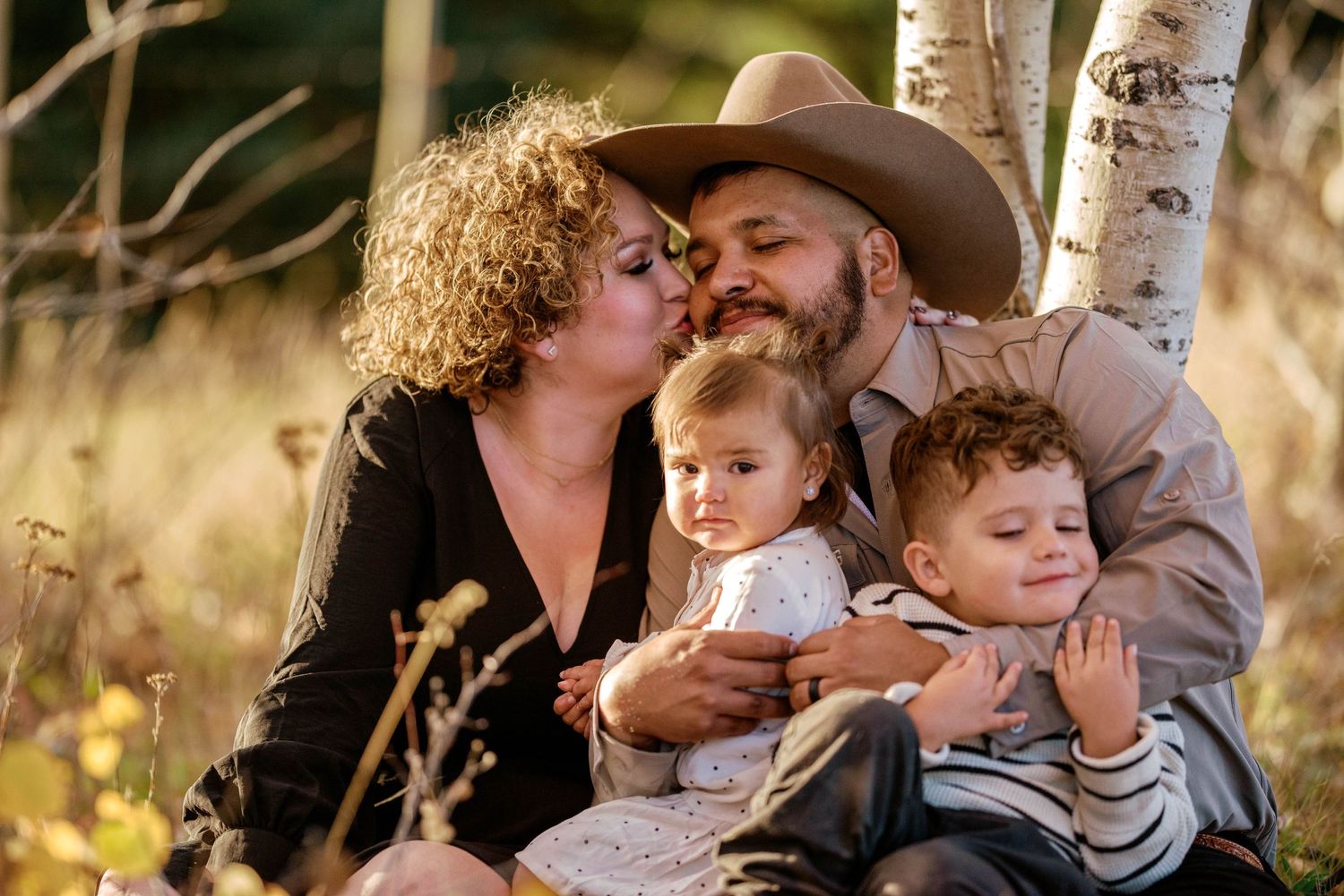 Family of four surrounded by autumn leaves in New Mexico — warm storytelling moment captured by The Amoras.