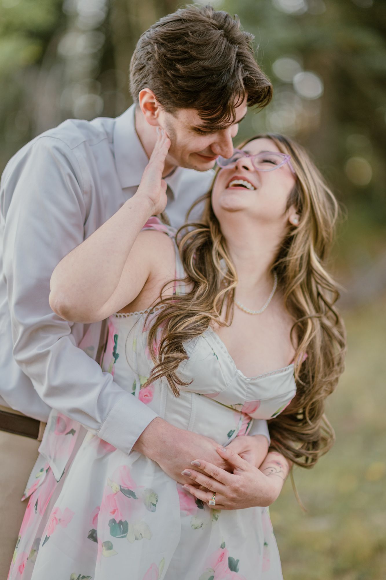 Couple laughing and embracing in a soft forest setting during a Chama, New Mexico engagement session.