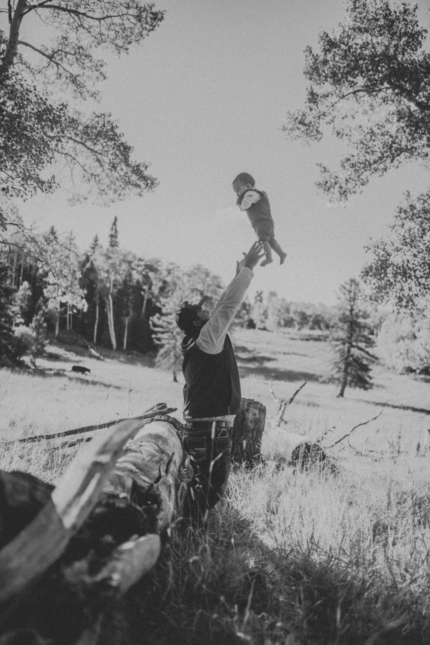 Black and white vintage photograph of people in an open field with trees.